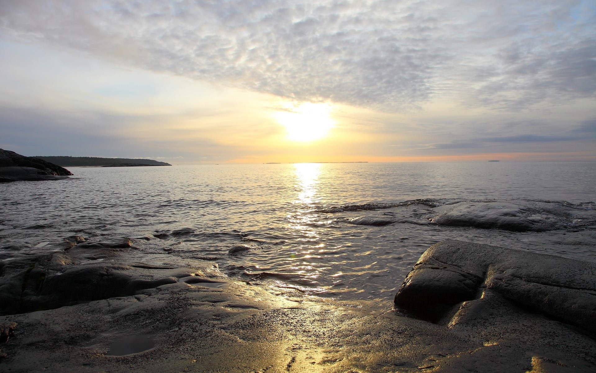 Sunset over a rocky shore and calm sea HD Wallpaper