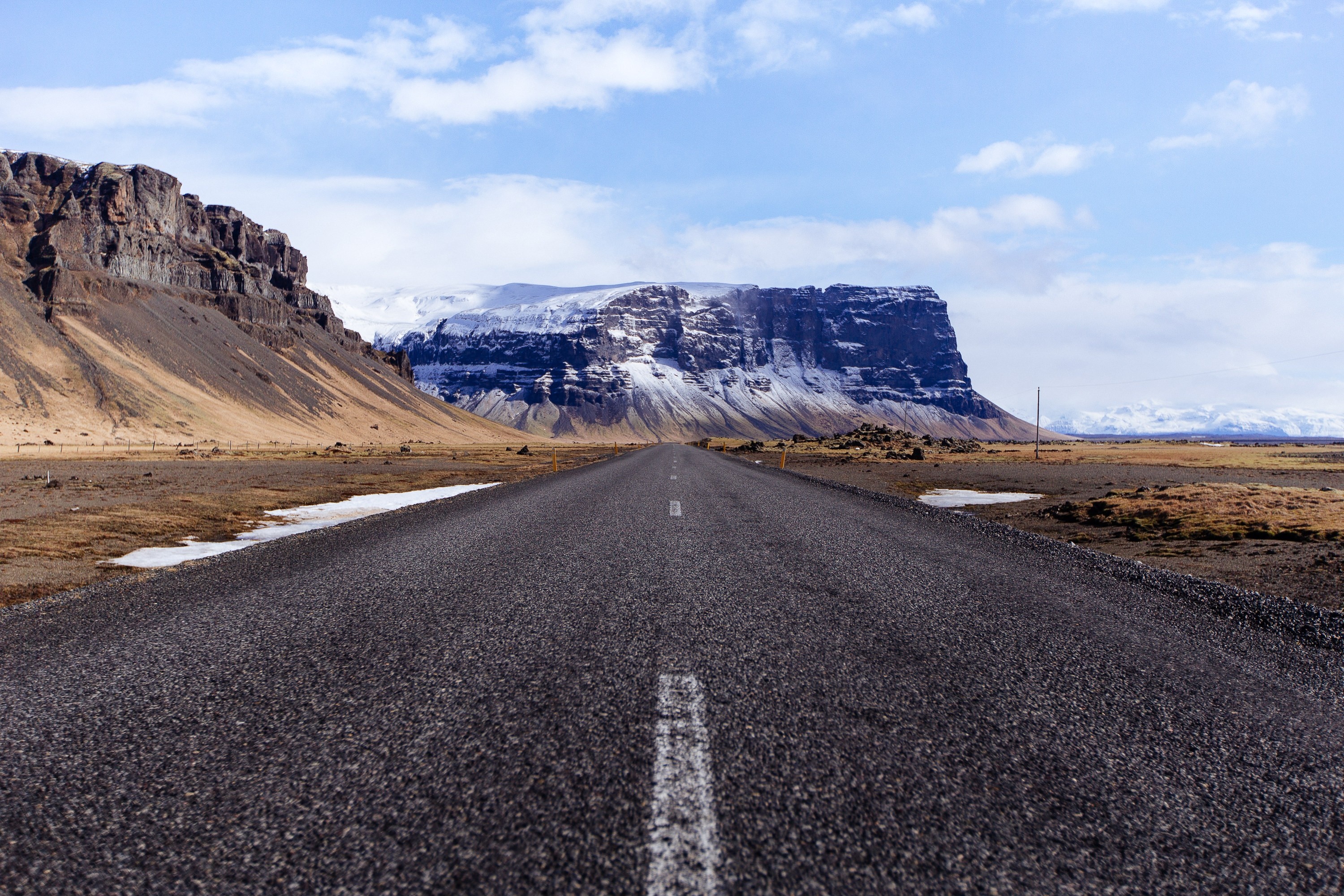 Road leading to a snow-capped mountain plateau HD Wallpaper