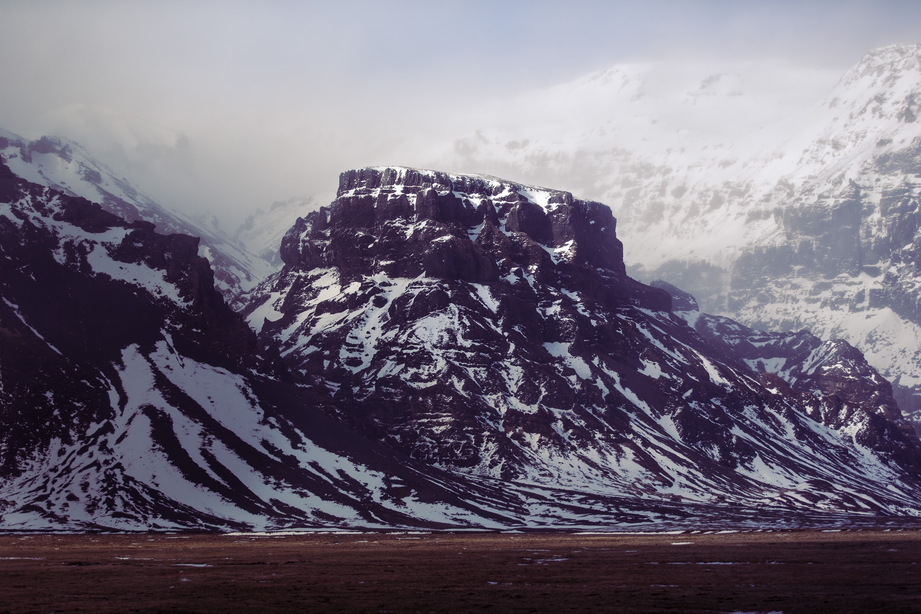 Snow-covered mountains with a flat-topped peak HD Wallpaper