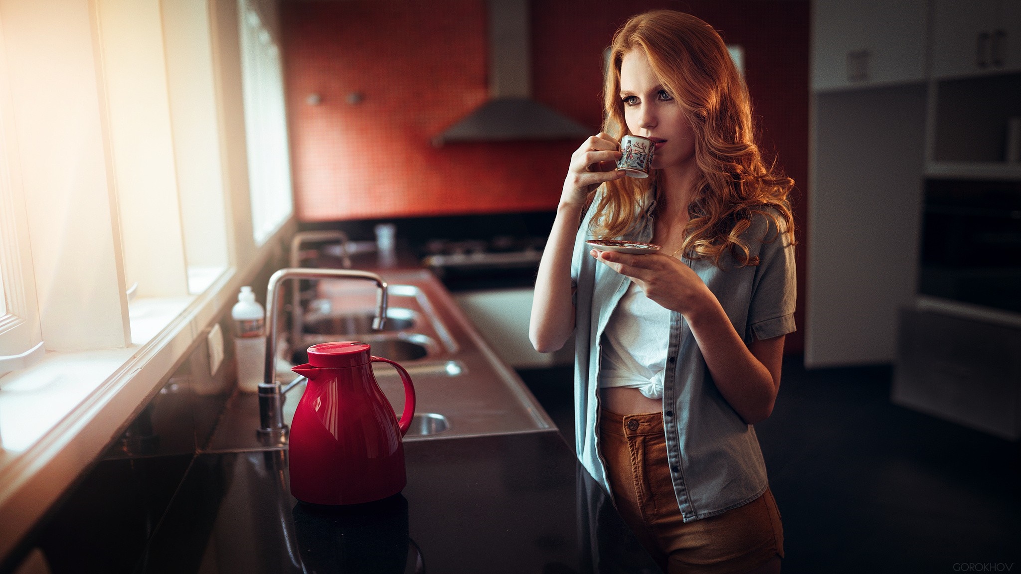 Woman with red hair drinking coffee in a kitchen HD Wallpaper