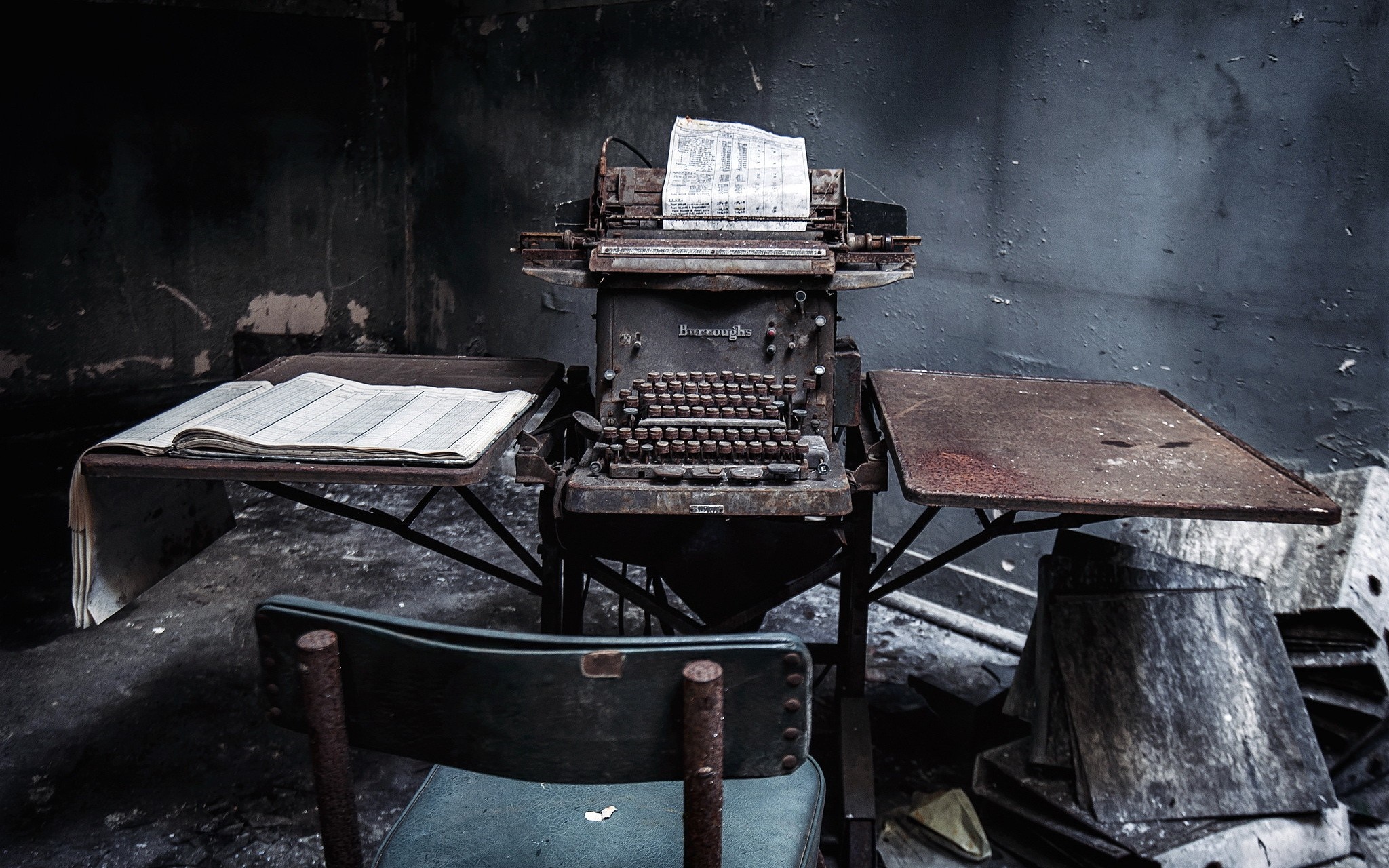 Abandoned Burroughs typewriter in a dark, ruined room HD Wallpaper