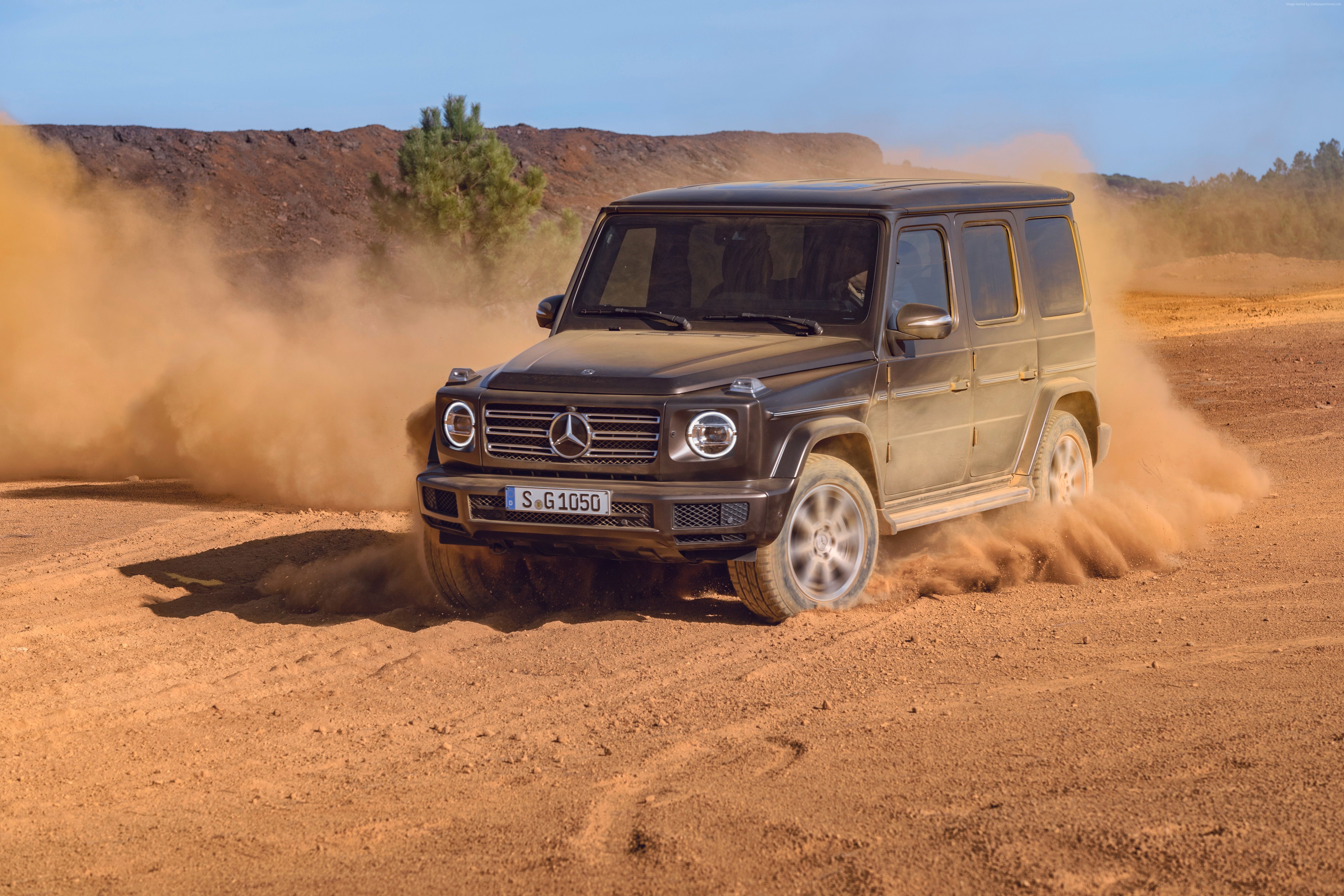 Mercedes-Benz G-Class driving on a dirt road HD Wallpaper