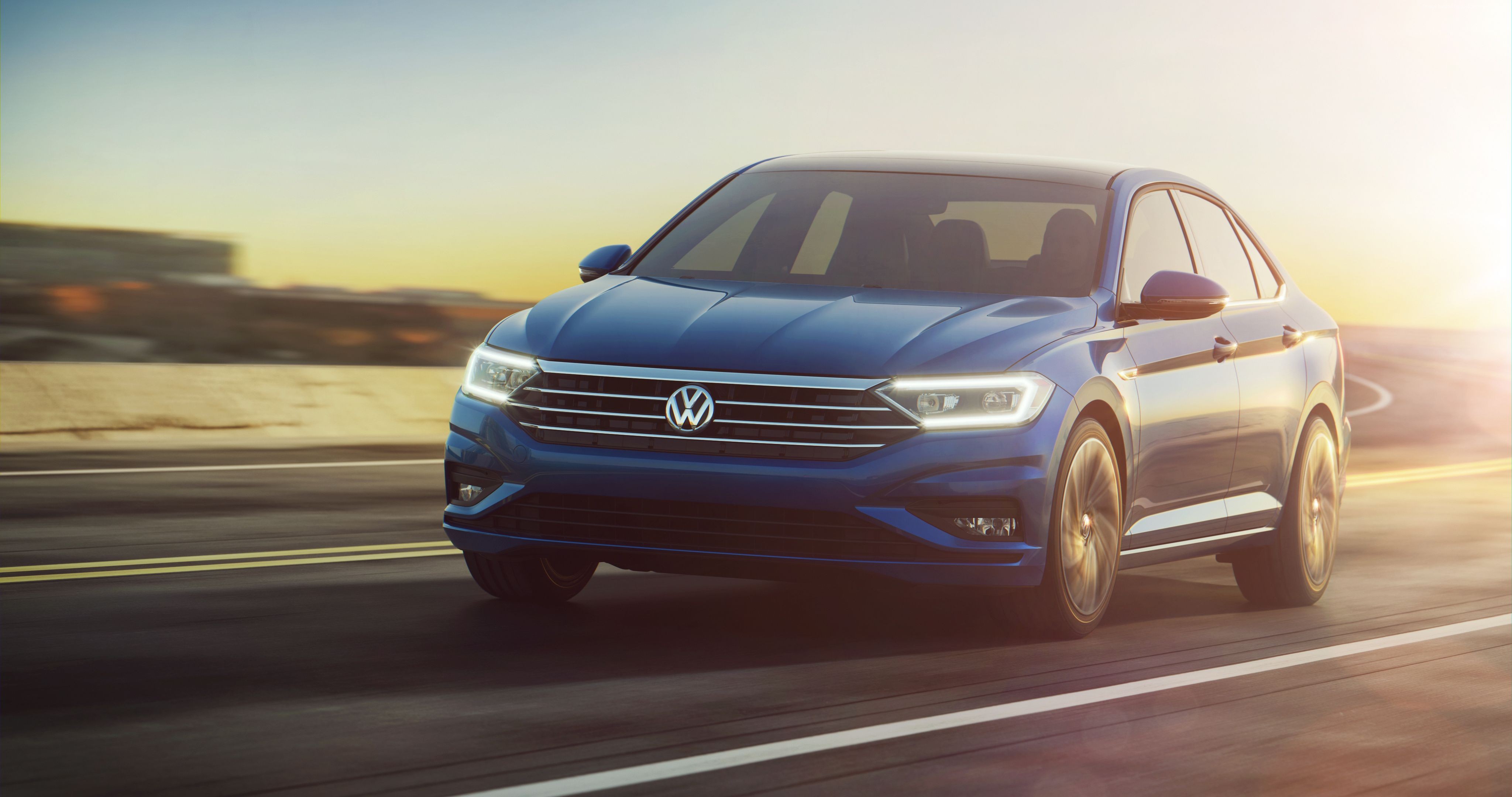 Blue 2018 Volkswagen Jetta driving on a road HD Wallpaper