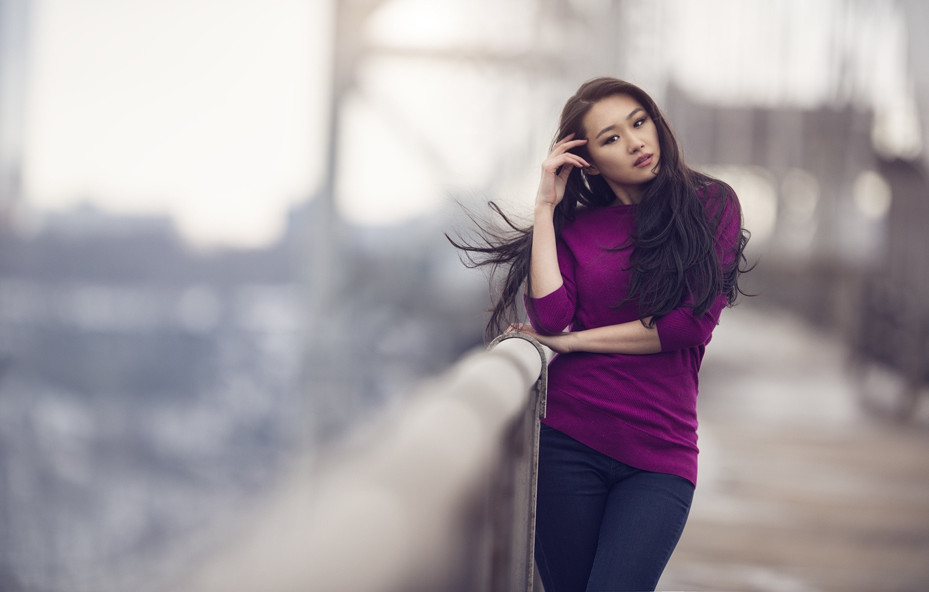 Asian woman posing on a bridge with wind blowing her hair HD Wallpaper