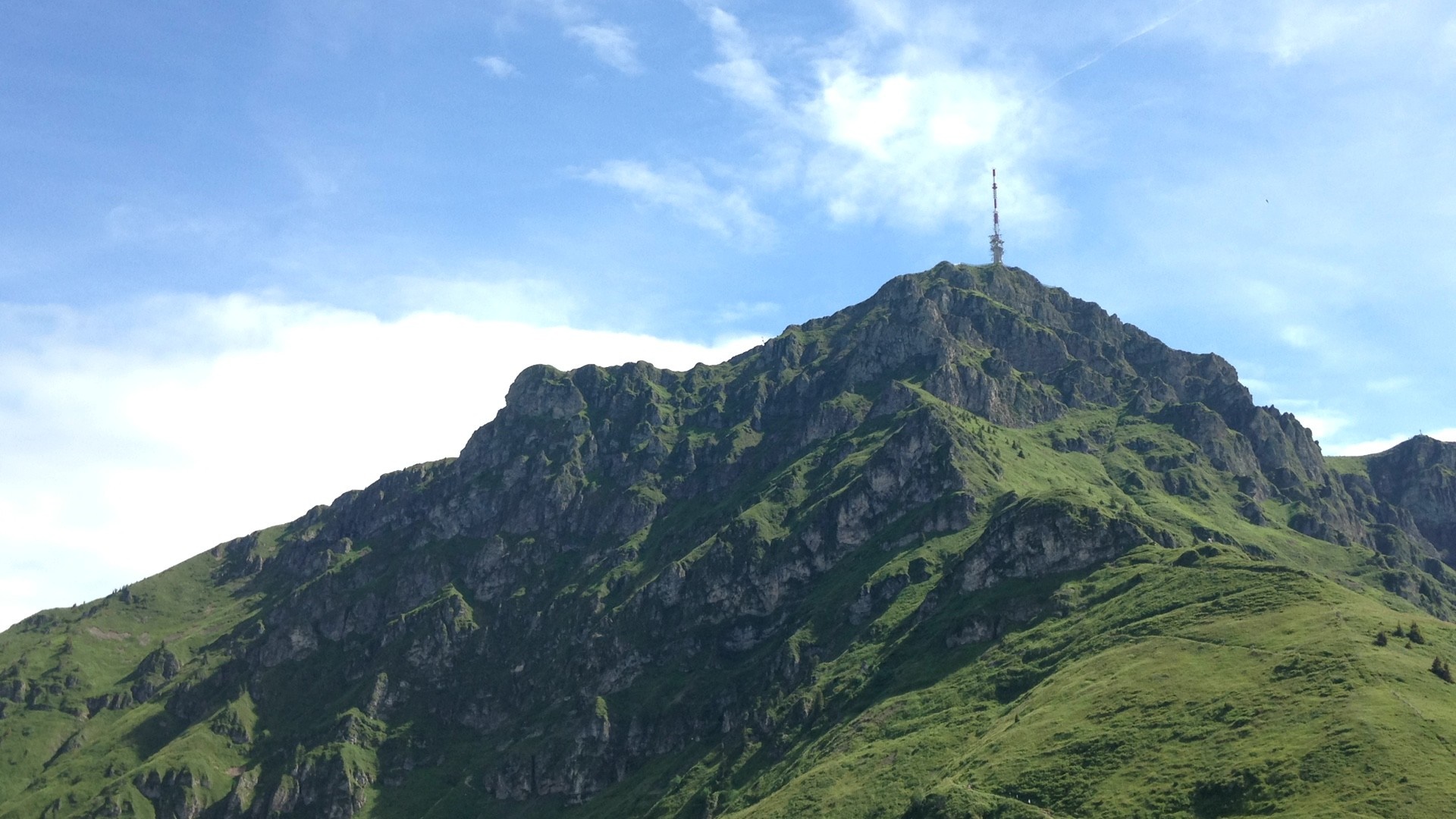 Mountain peak with a radio tower under a blue sky HD Wallpaper