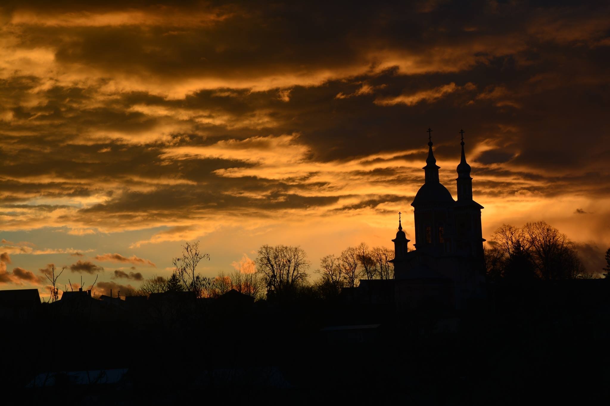 Silhouette of church towers against a dramatic sunset sky HD Wallpaper