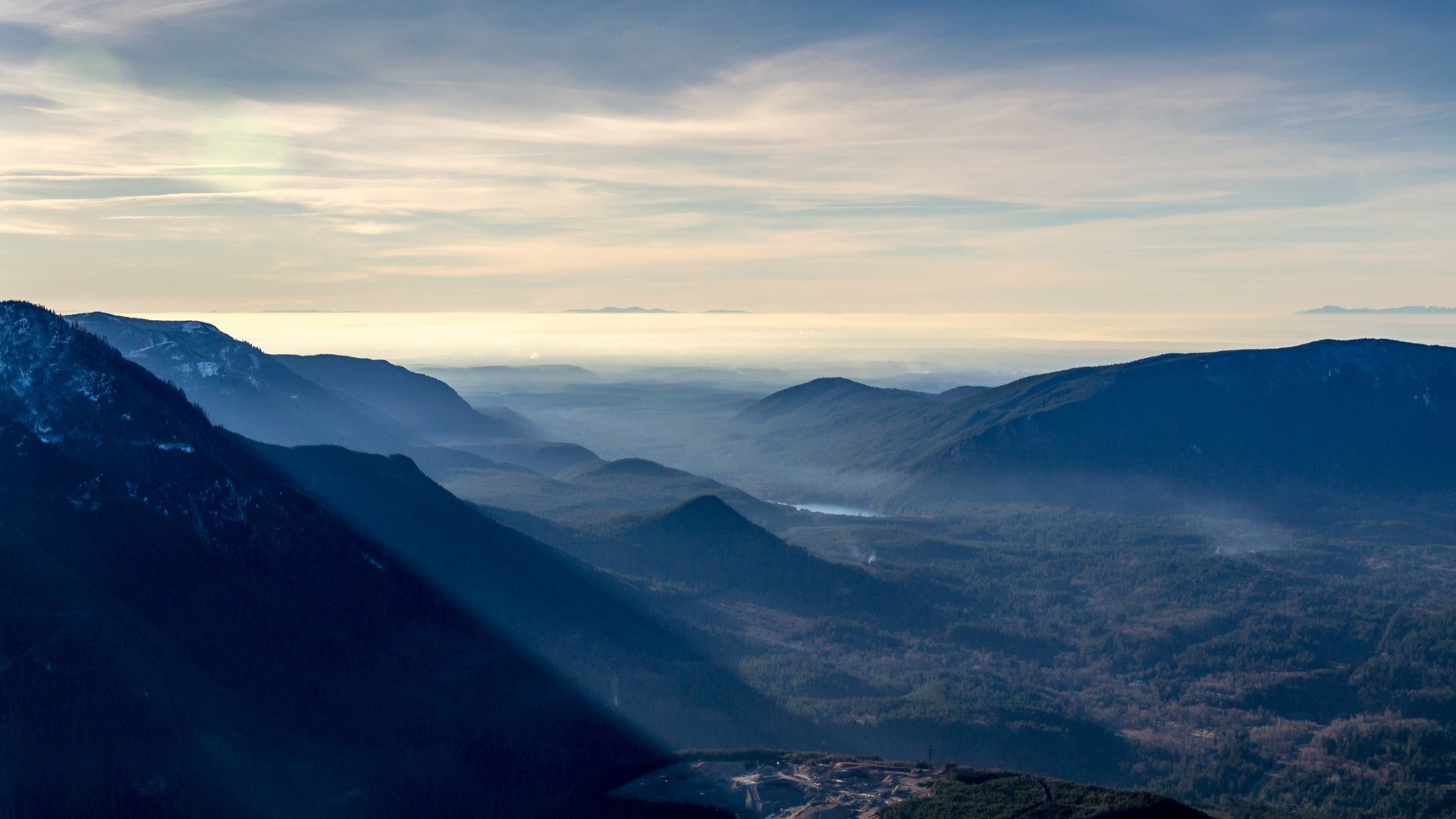 Misty mountain range at sunrise with sunbeams HD Wallpaper