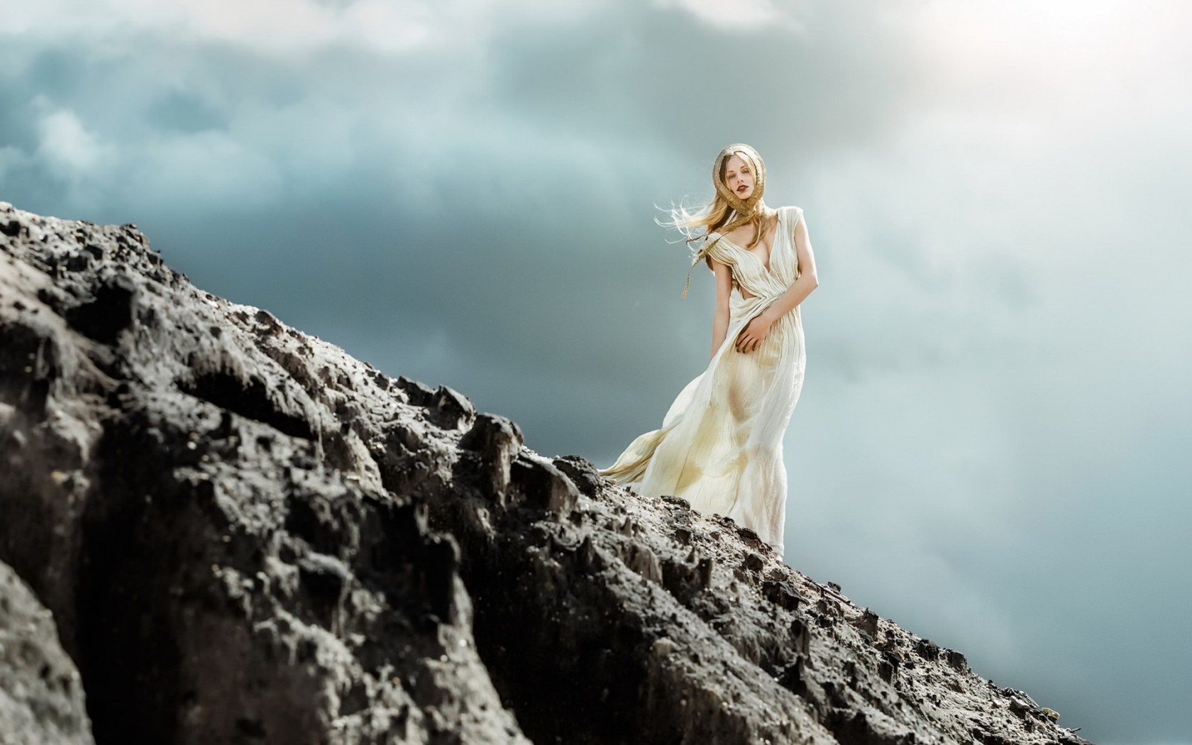 Woman in a flowing dress on a rocky landscape HD Wallpaper