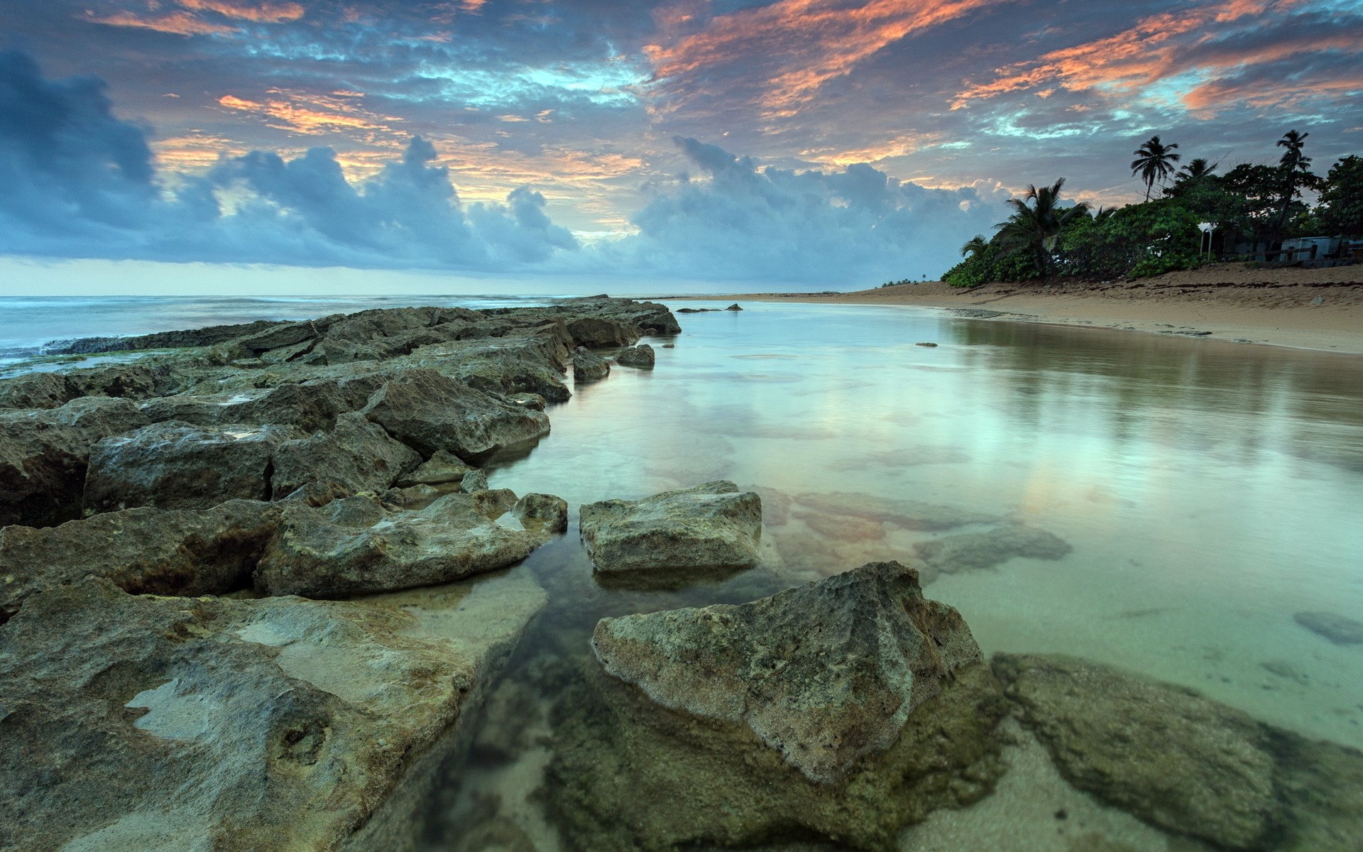Rocky coastline at sunset with colorful clouds HD Wallpaper
