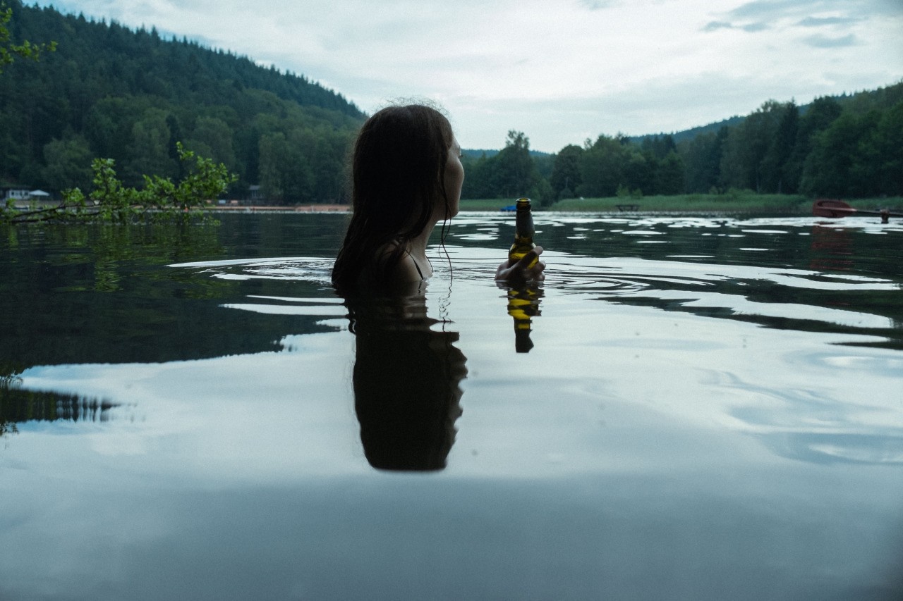 Woman in lake holding a beer bottle HD Wallpaper