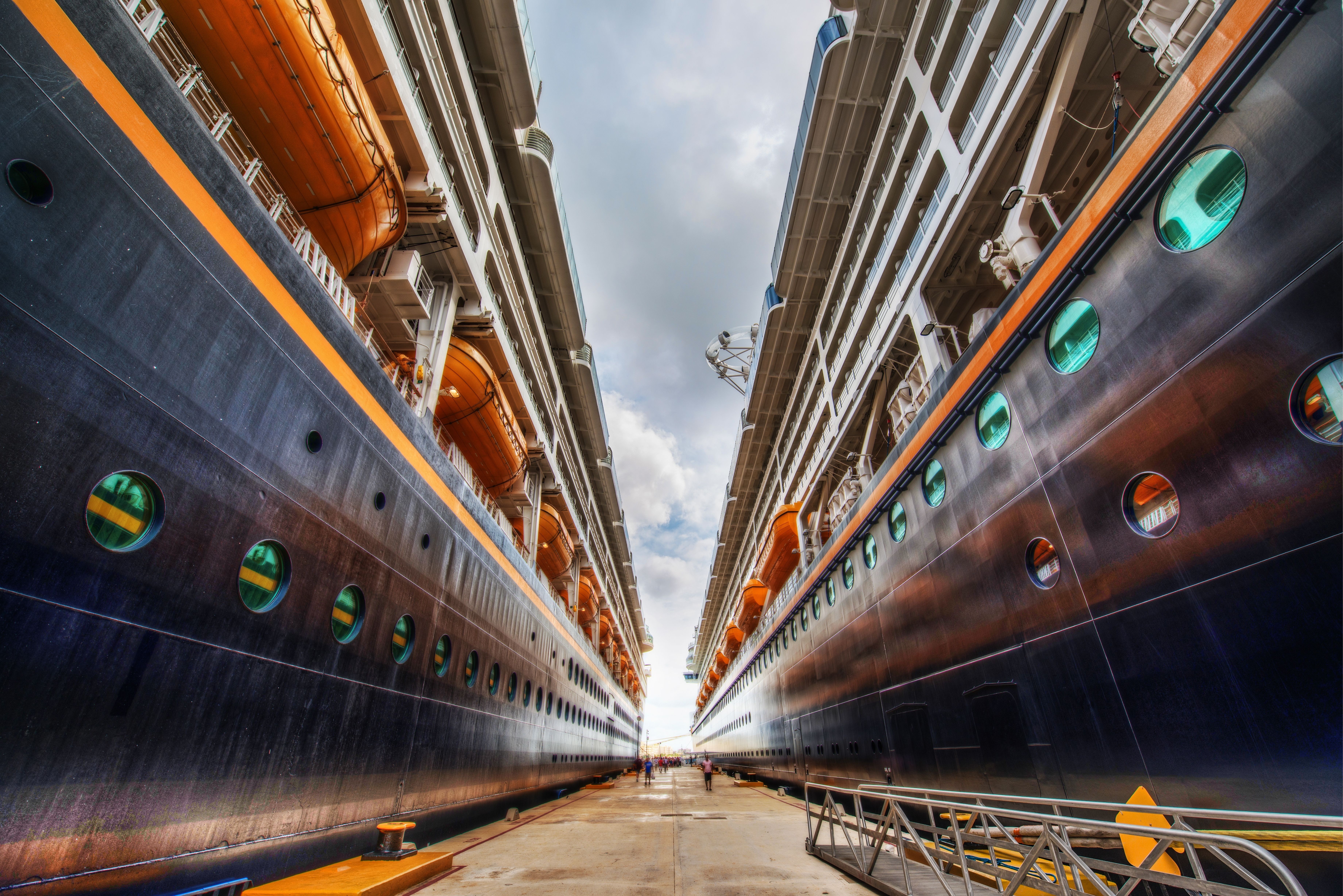 Two cruise ships docked side-by-side at a port HD Wallpaper