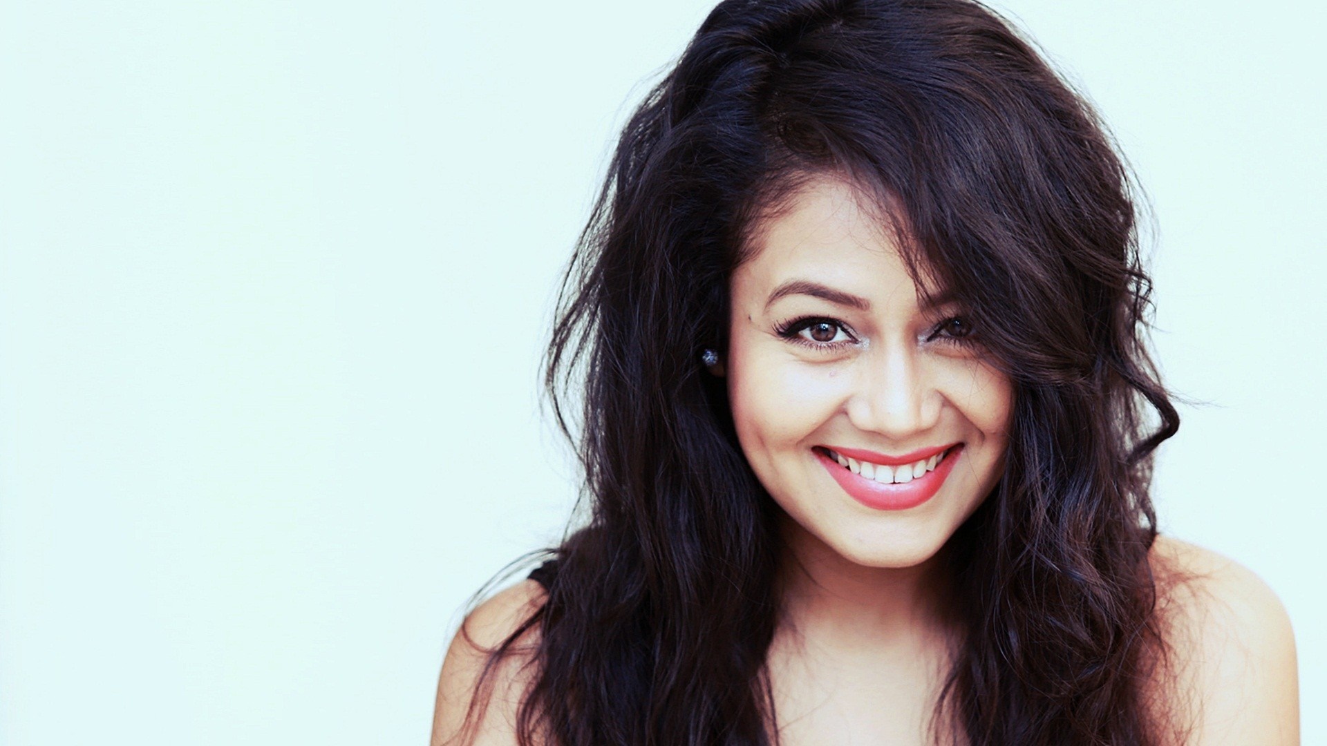 Neha Kakkar smiling with long dark hair HD Wallpaper