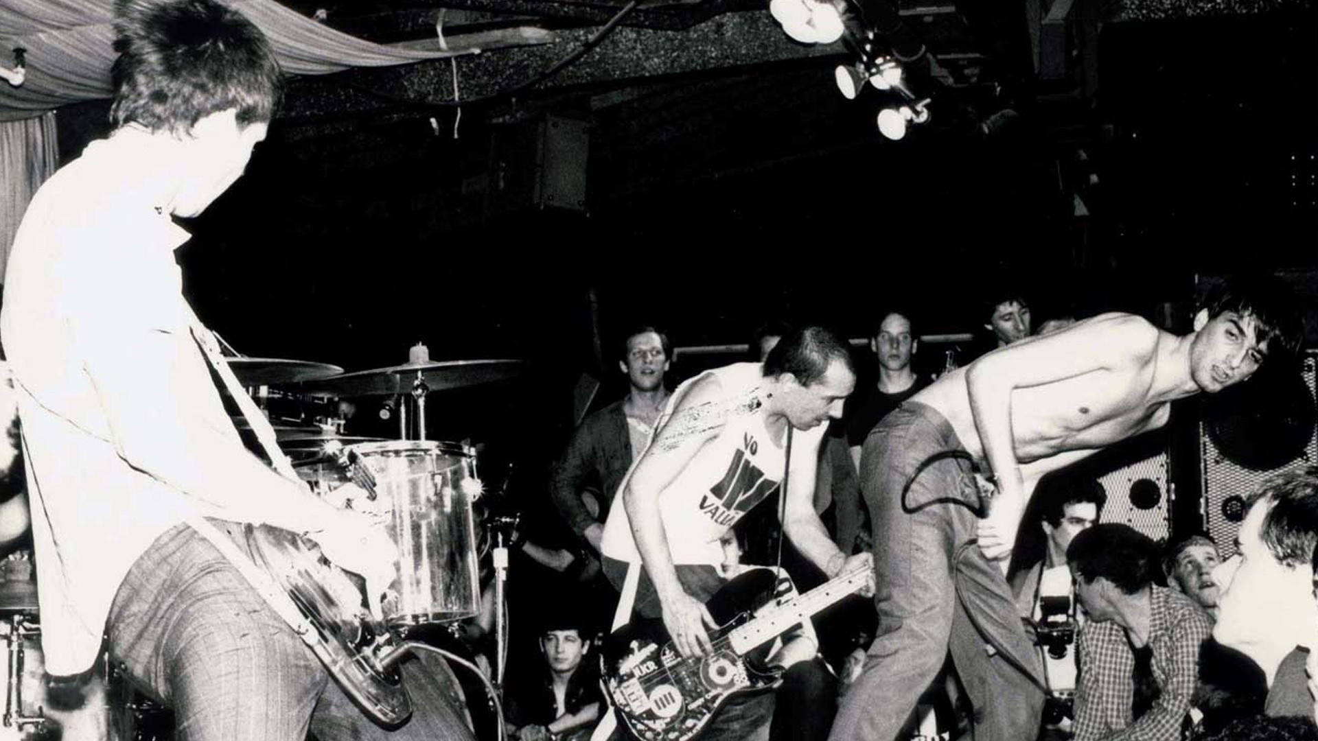 Band performing live music on stage with audience HD Wallpaper