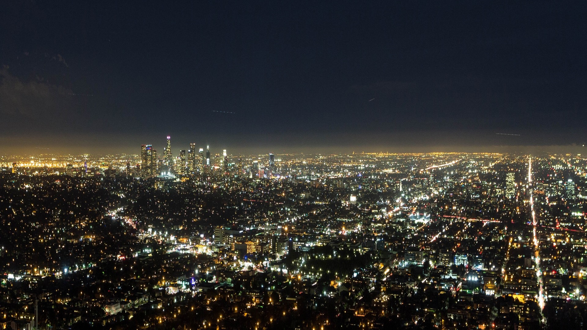 Nighttime panorama of a sprawling city skyline HD Wallpaper