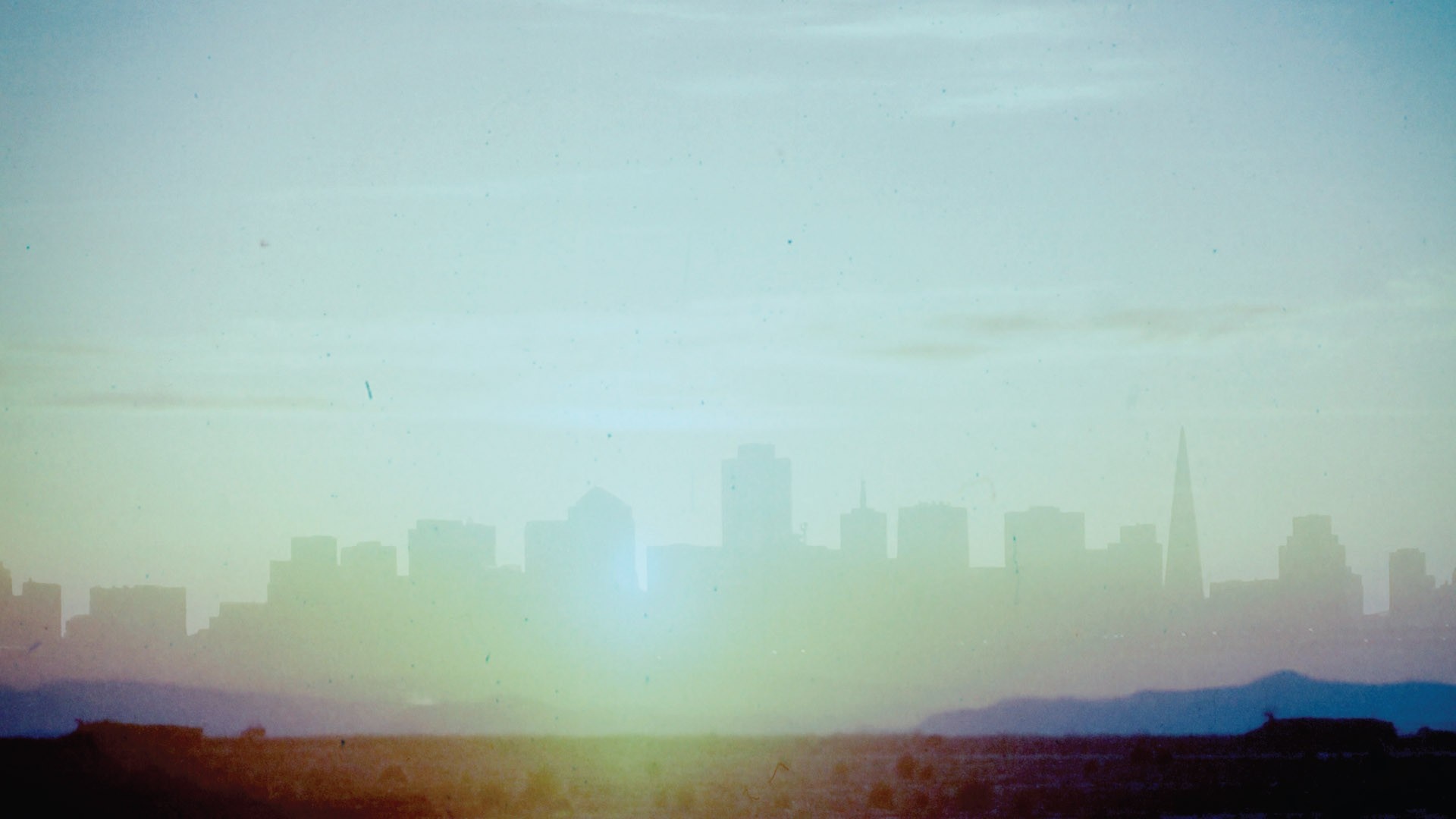 City skyline at sunrise with haze HD Wallpaper