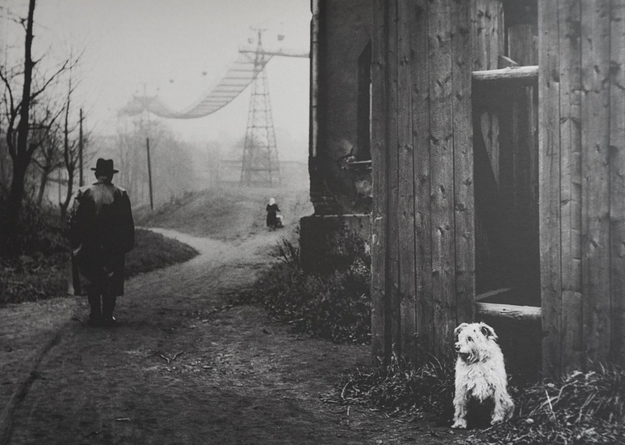 Man and child walk on a path near industrial structures HD Wallpaper