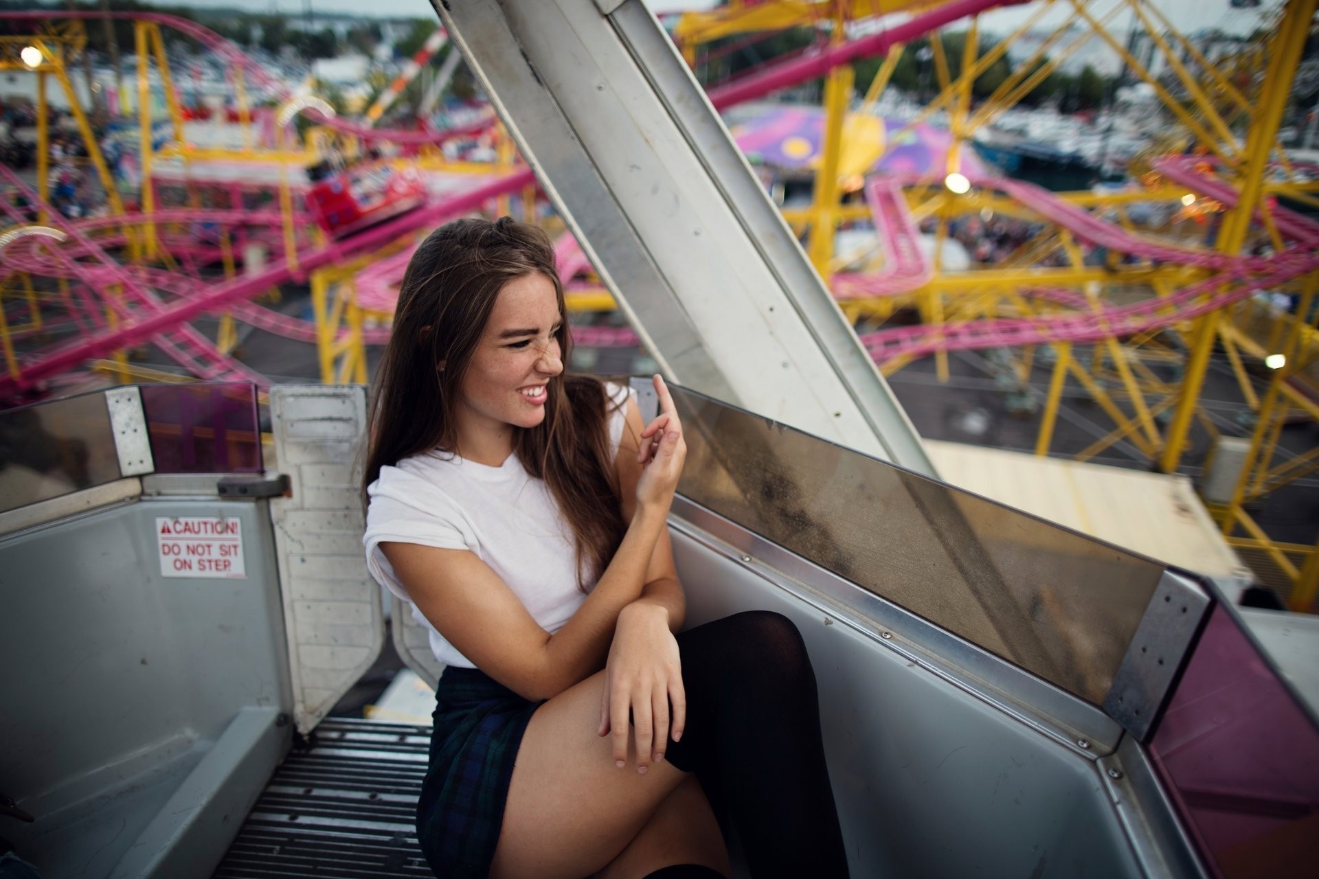 Woman in white top and plaid skirt on amusement ride HD Wallpaper