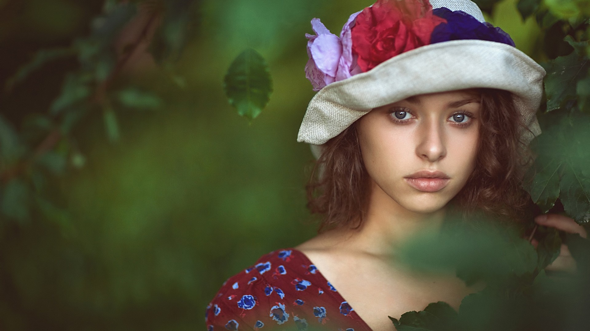 Woman wearing a hat with flowers in a garden HD Wallpaper