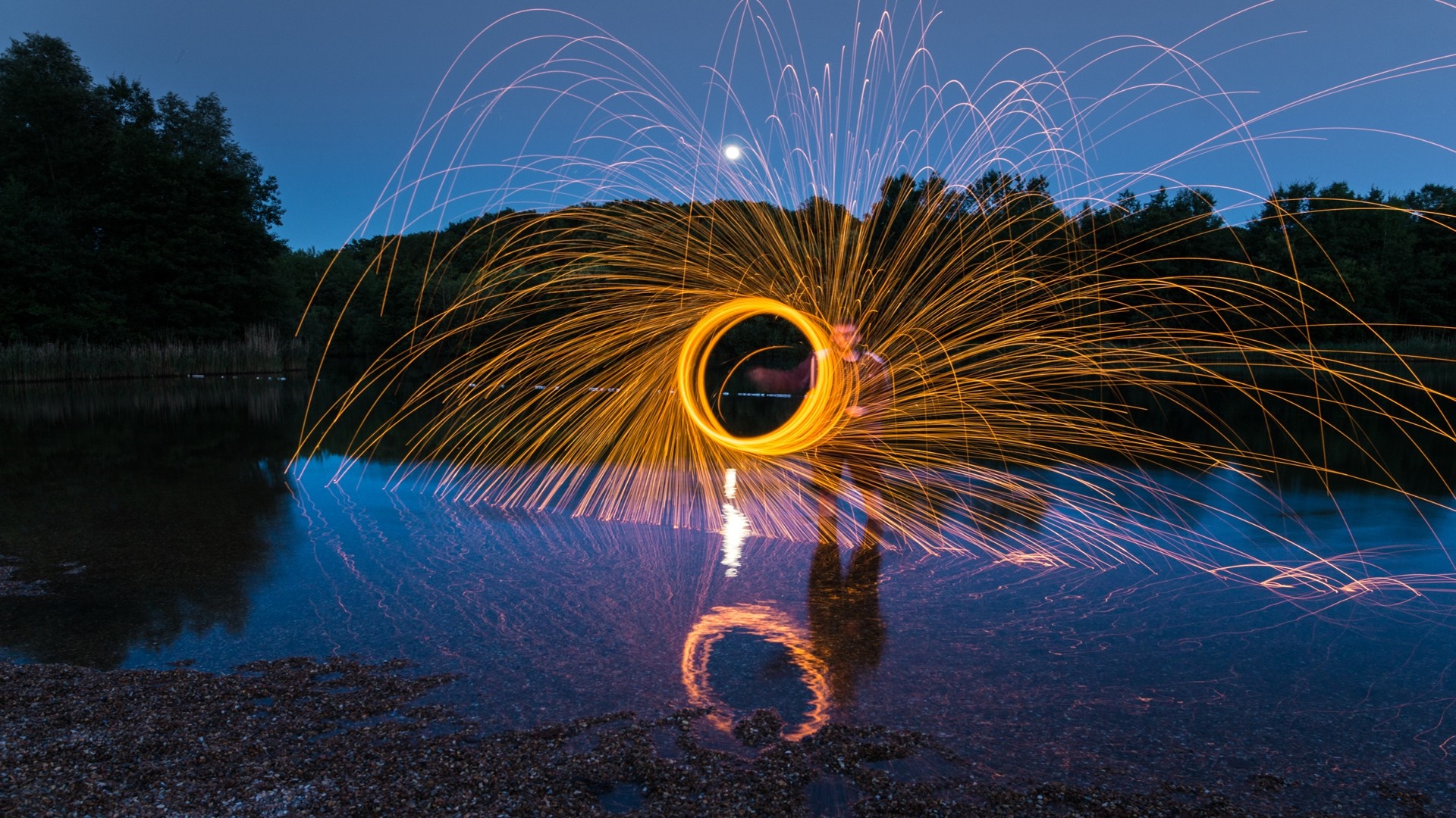 Light painting with sparks over water at night HD Wallpaper