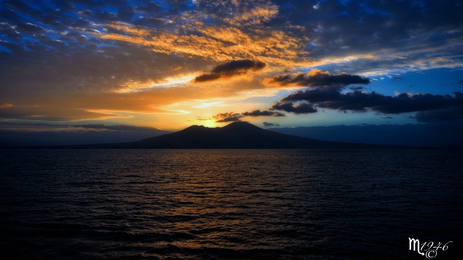 Sunset over the sea with a mountain silhouette HD Wallpaper