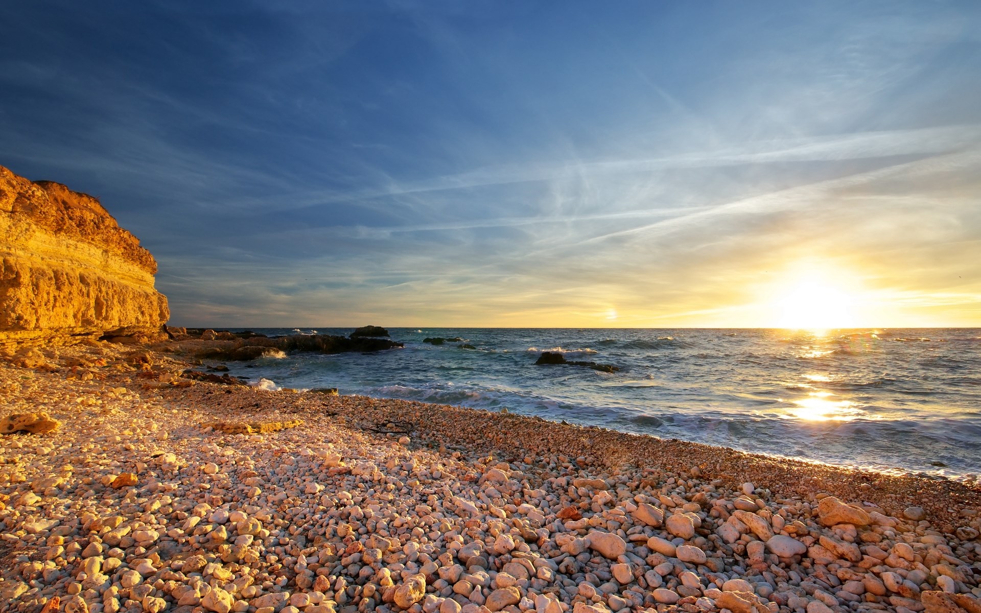 Sunset over a rocky beach and cliff HD Wallpaper