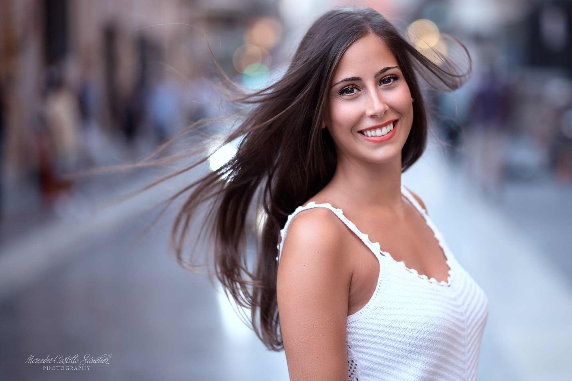 Woman with long brown hair smiling outdoors HD Wallpaper