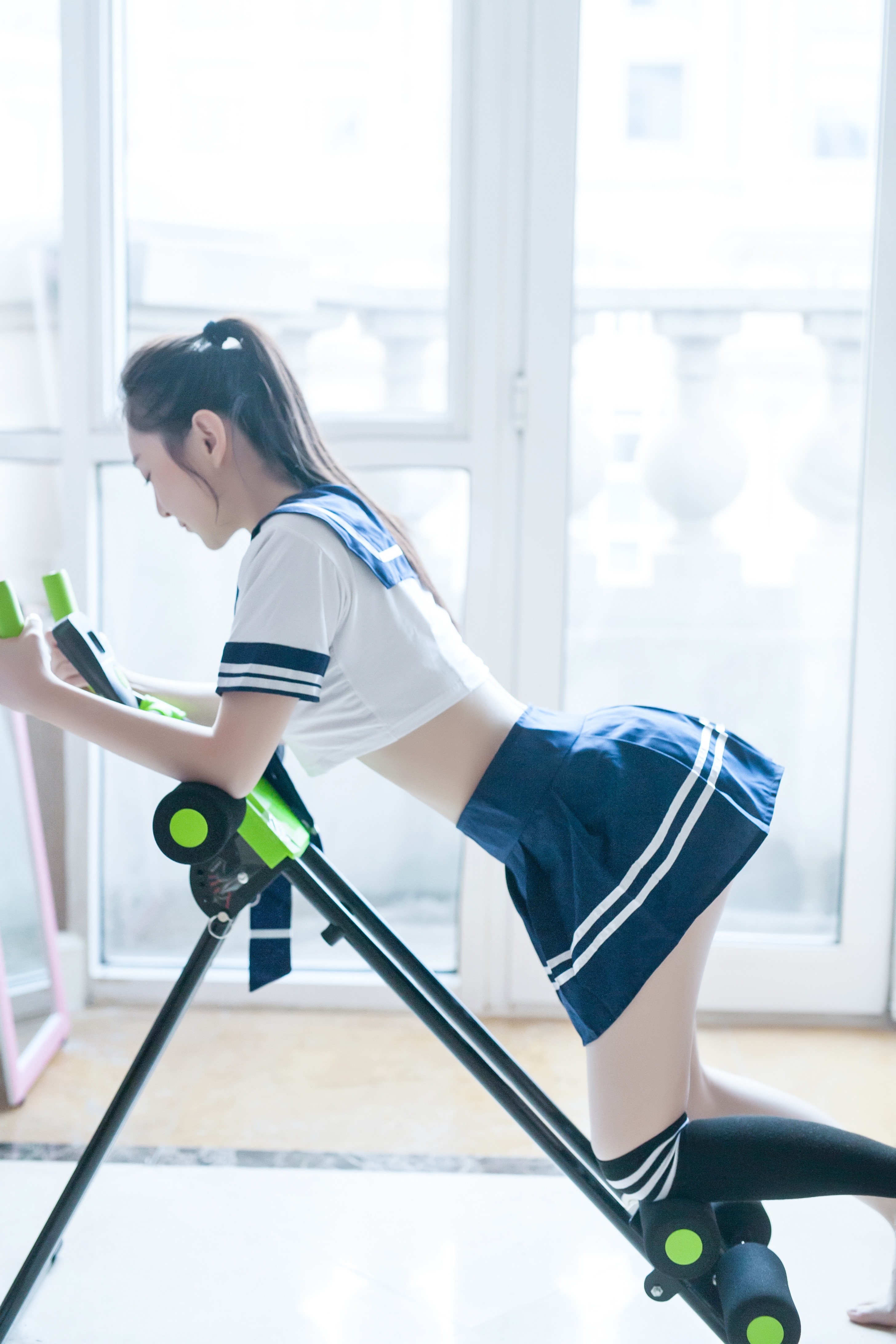 Asian woman in school uniform on exercise machine HD Wallpaper