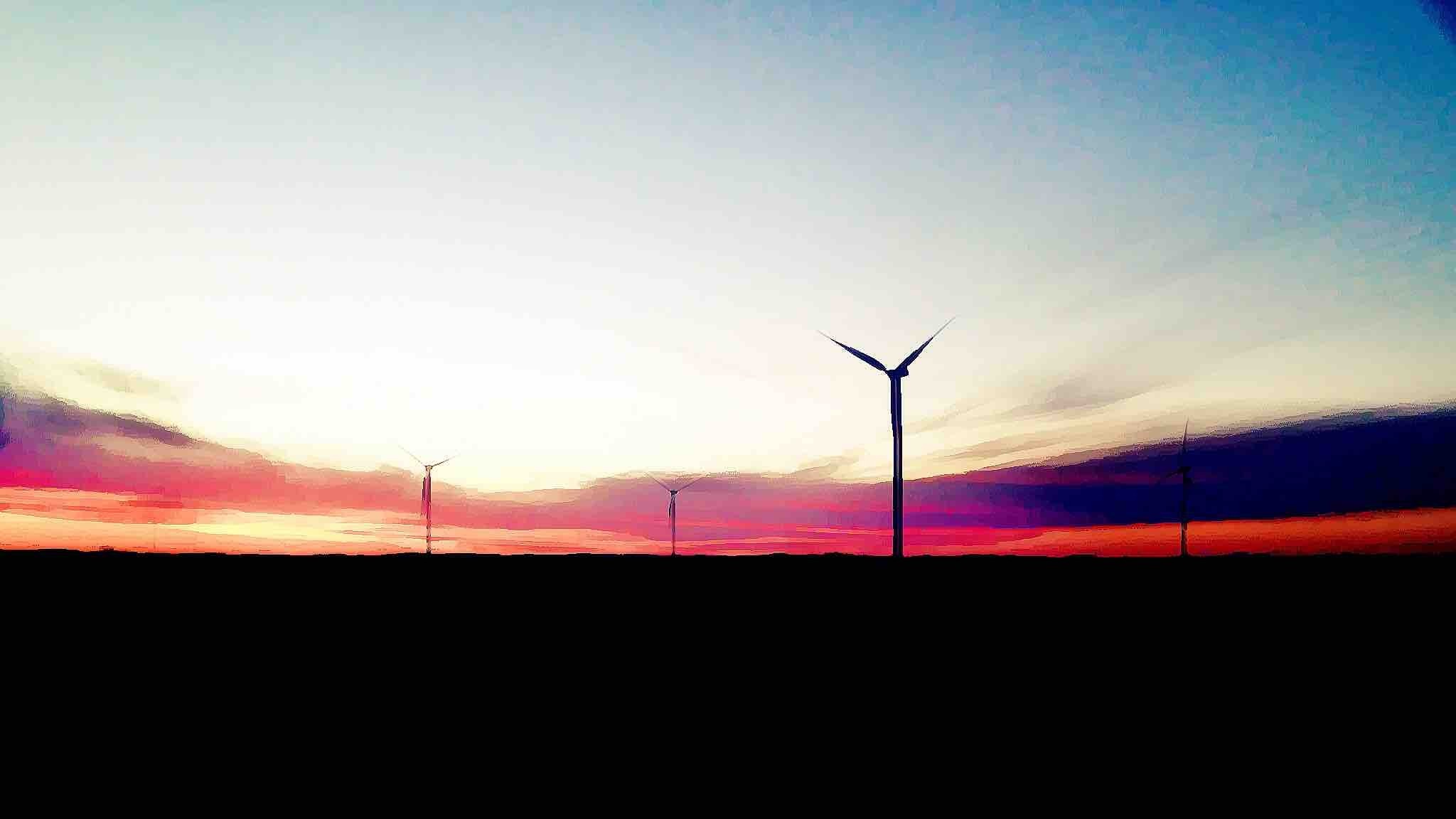 Windmills silhouetted against a colorful sunset sky HD Wallpaper