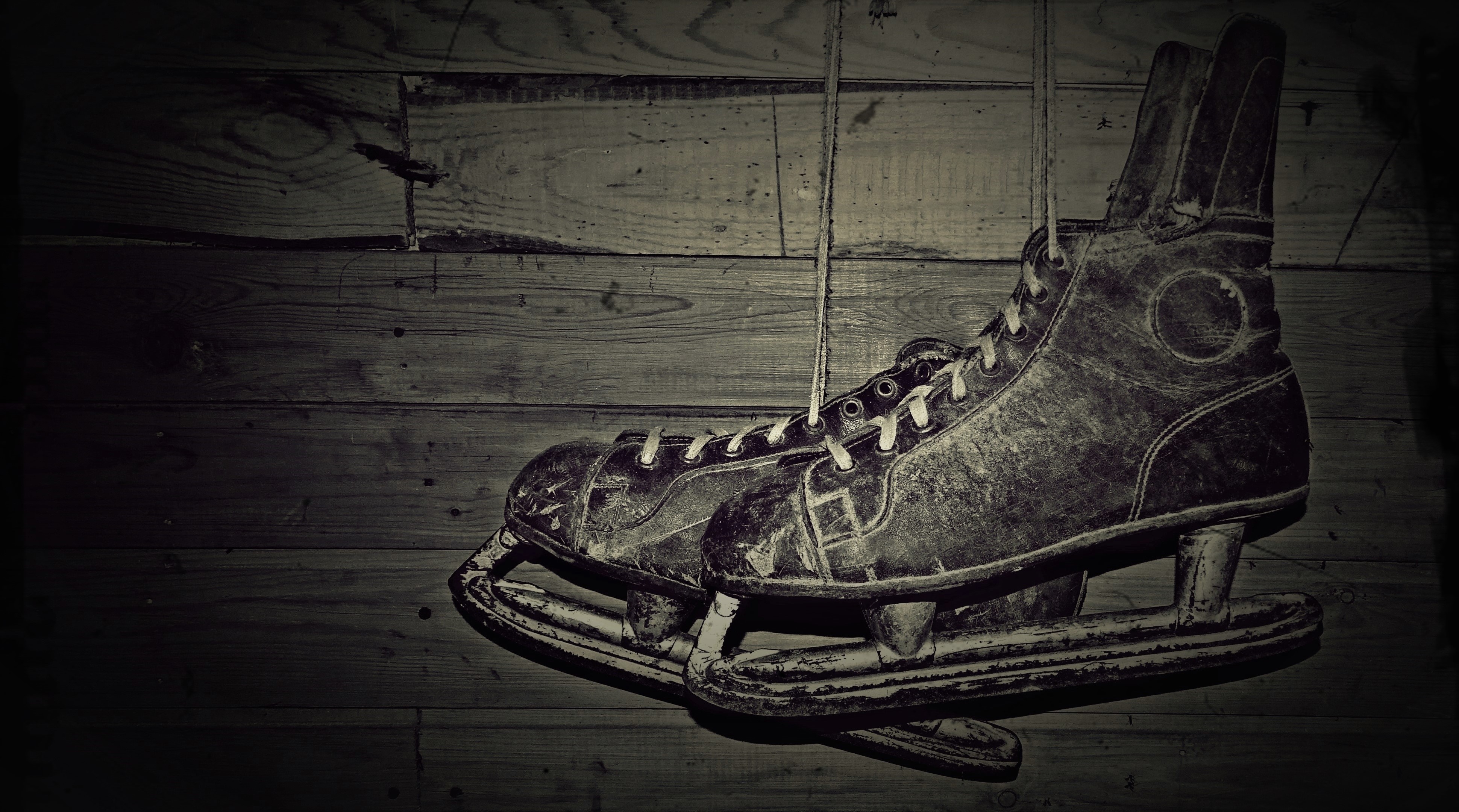 Old ice skates hanging on a wooden wall HD Wallpaper