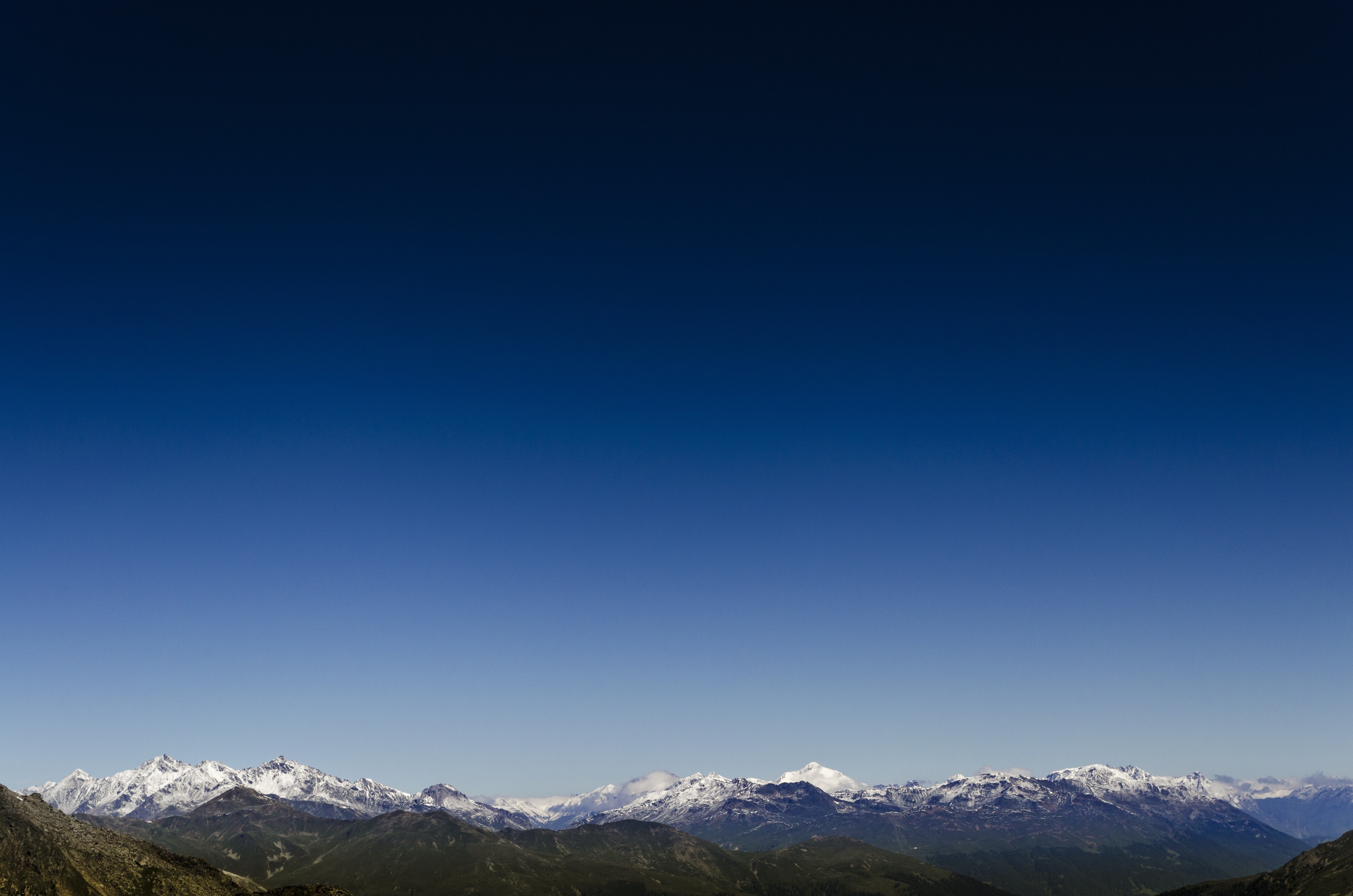Snow-capped mountains under a clear blue sky HD Wallpaper