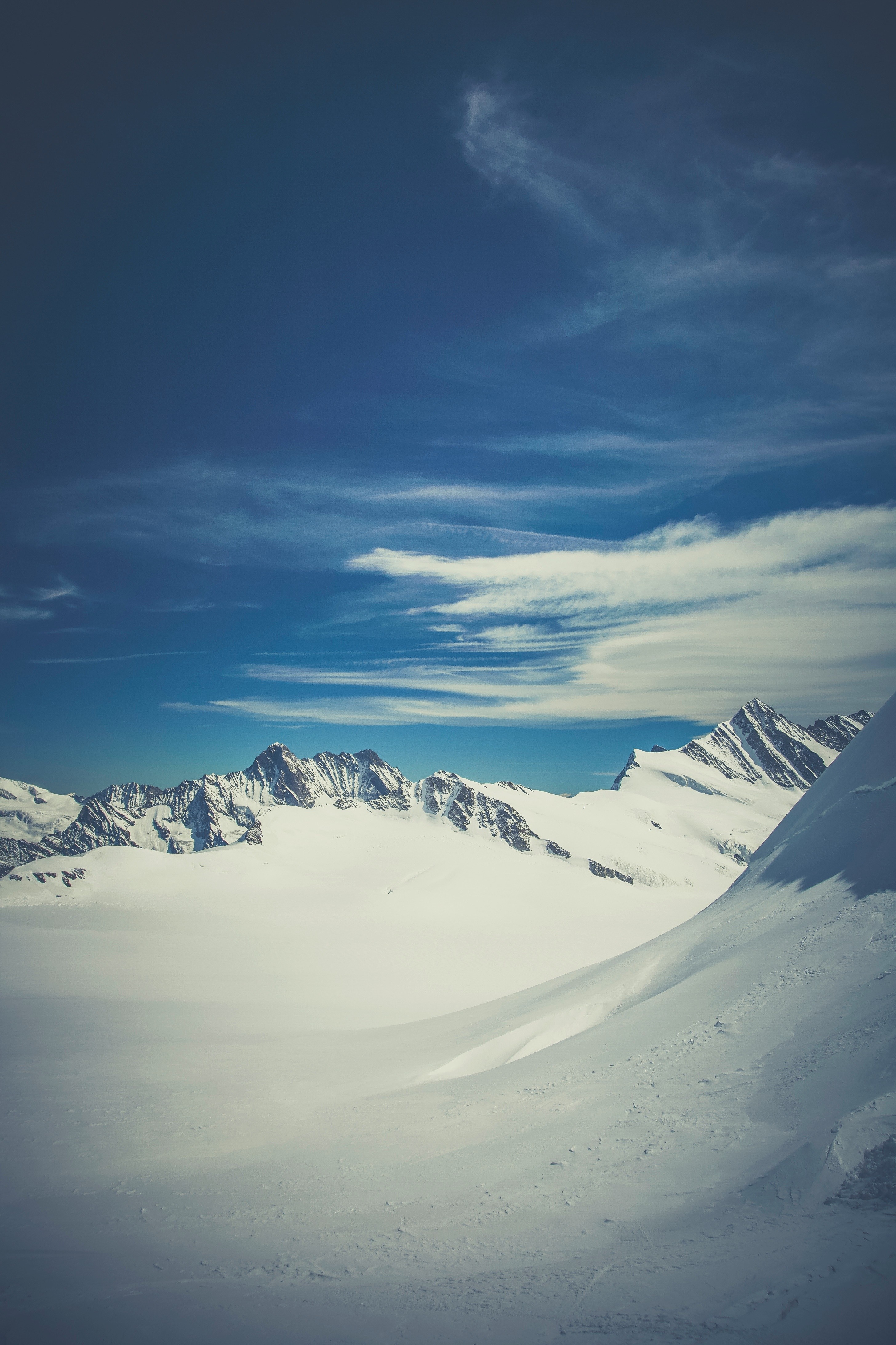 Snowy mountain range under a blue sky with clouds HD Wallpaper