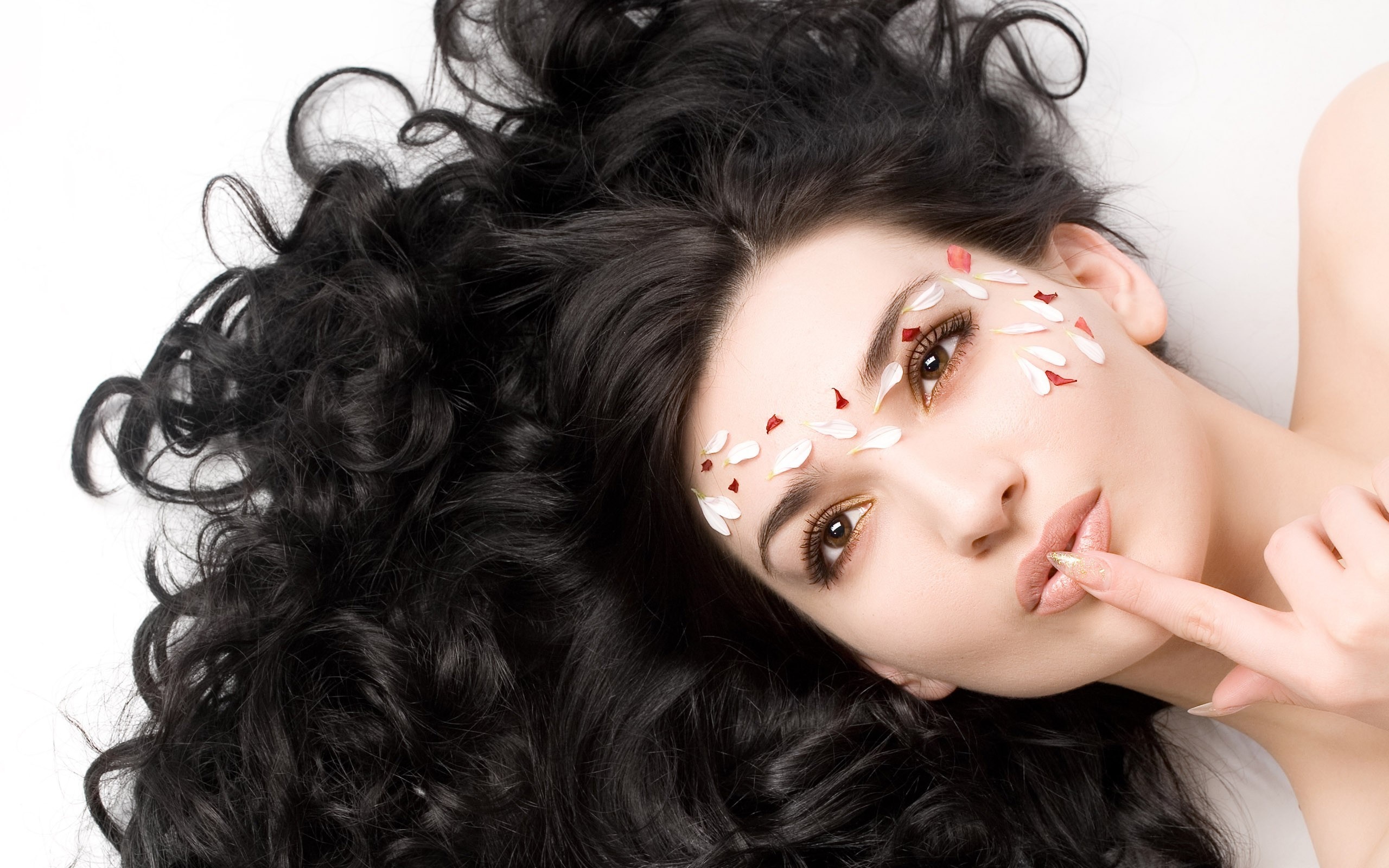 Woman with Long Curly Black Hair and Petals on Face HD Wallpaper