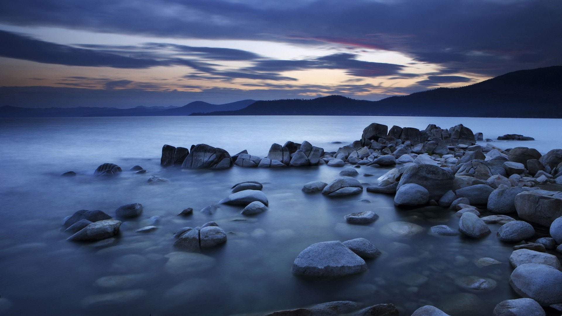 Rocky shore of a lake at dusk HD Wallpaper