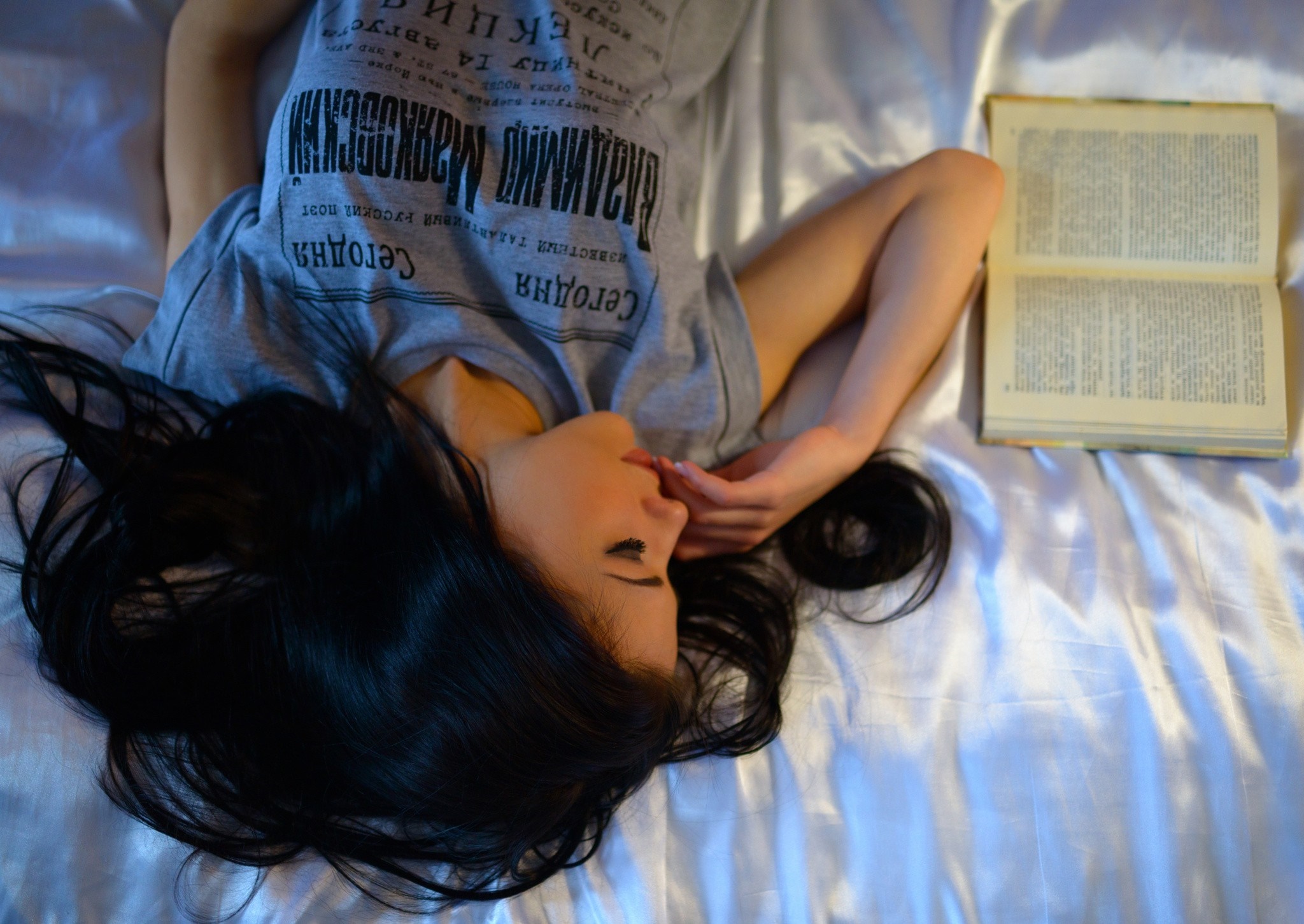 Woman lying on bed with open book HD Wallpaper