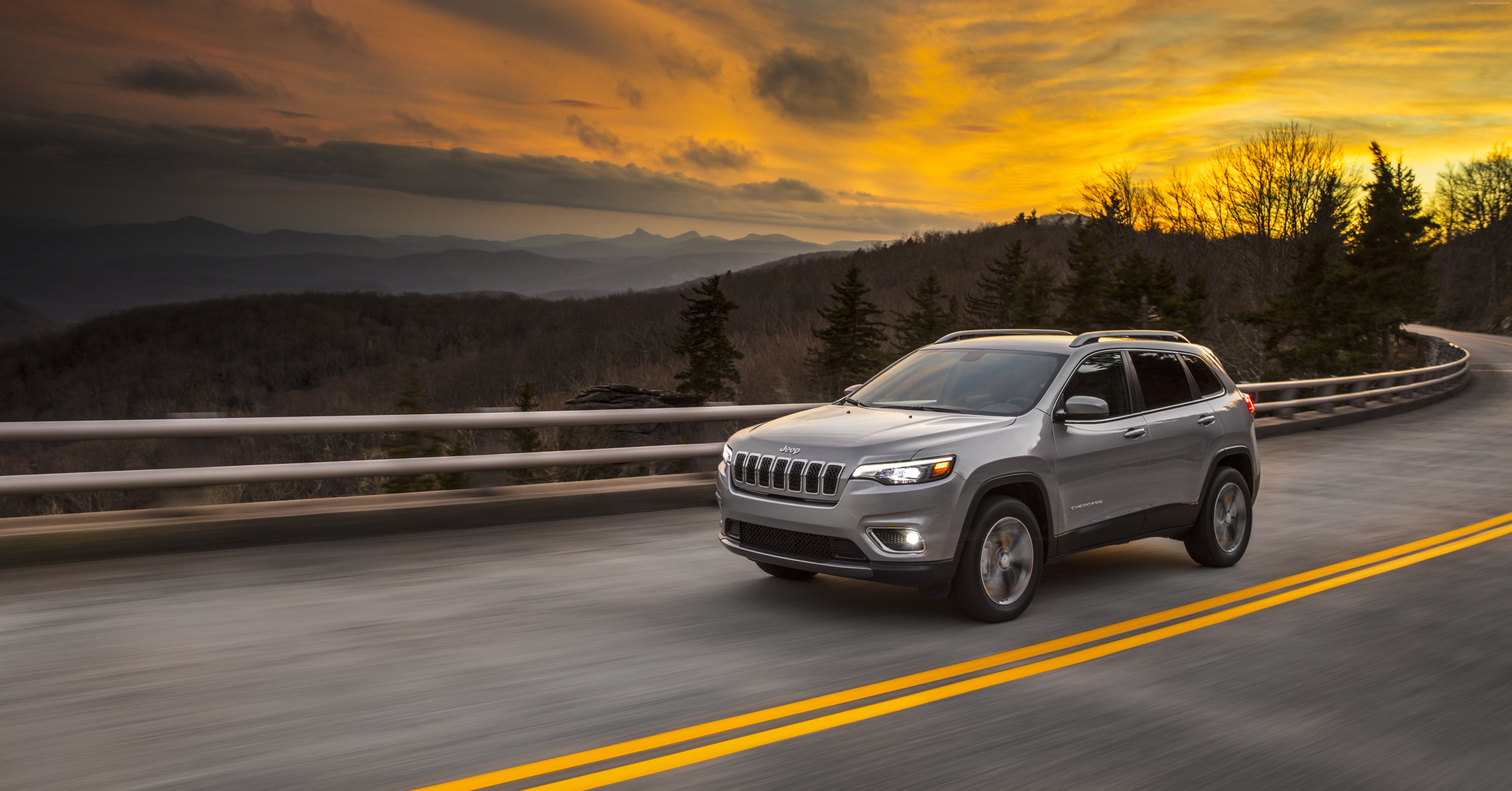 Silver Jeep Cherokee driving on mountain road at sunset HD Wallpaper
