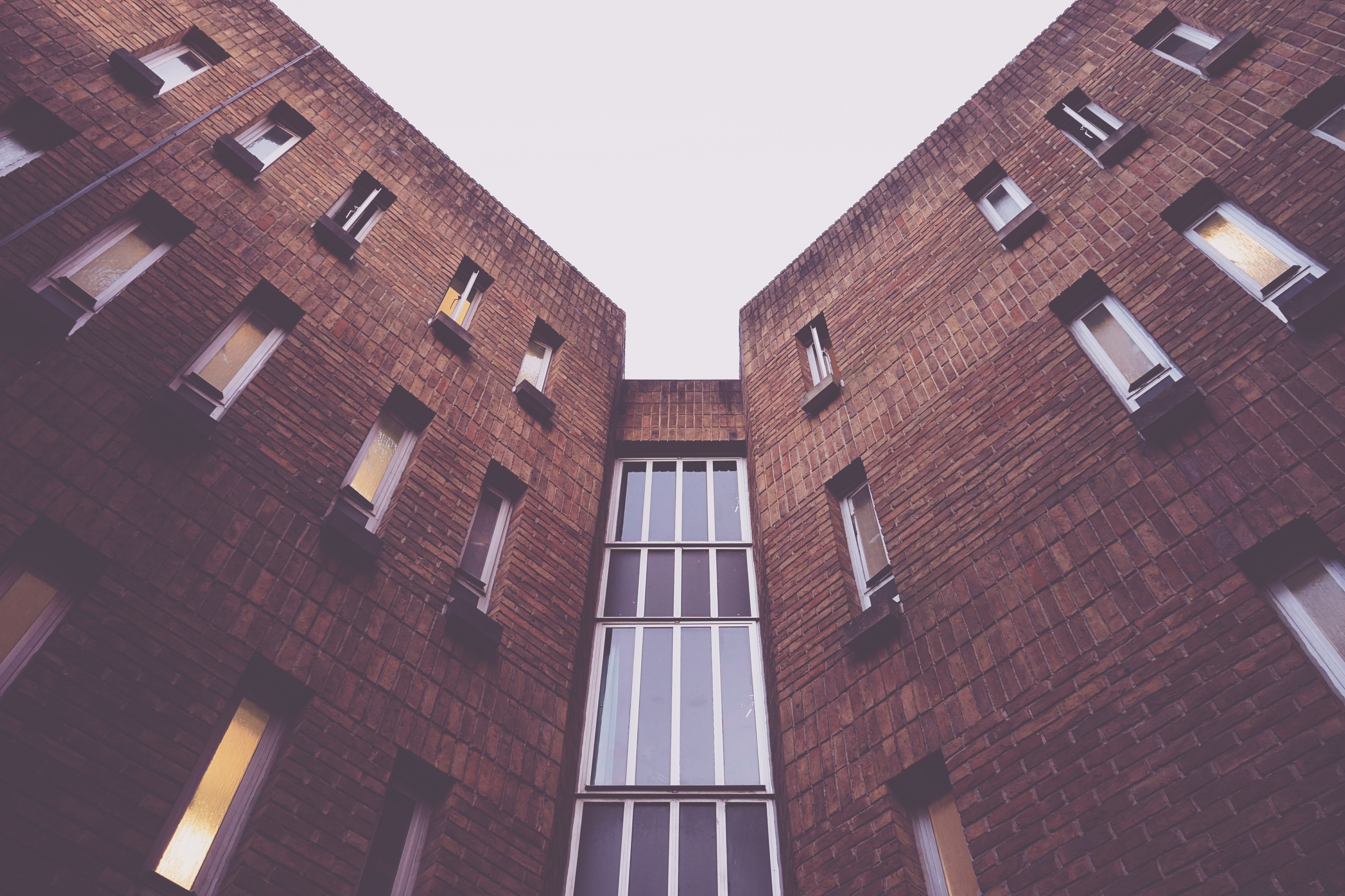 Brick building with many windows viewed from below HD Wallpaper