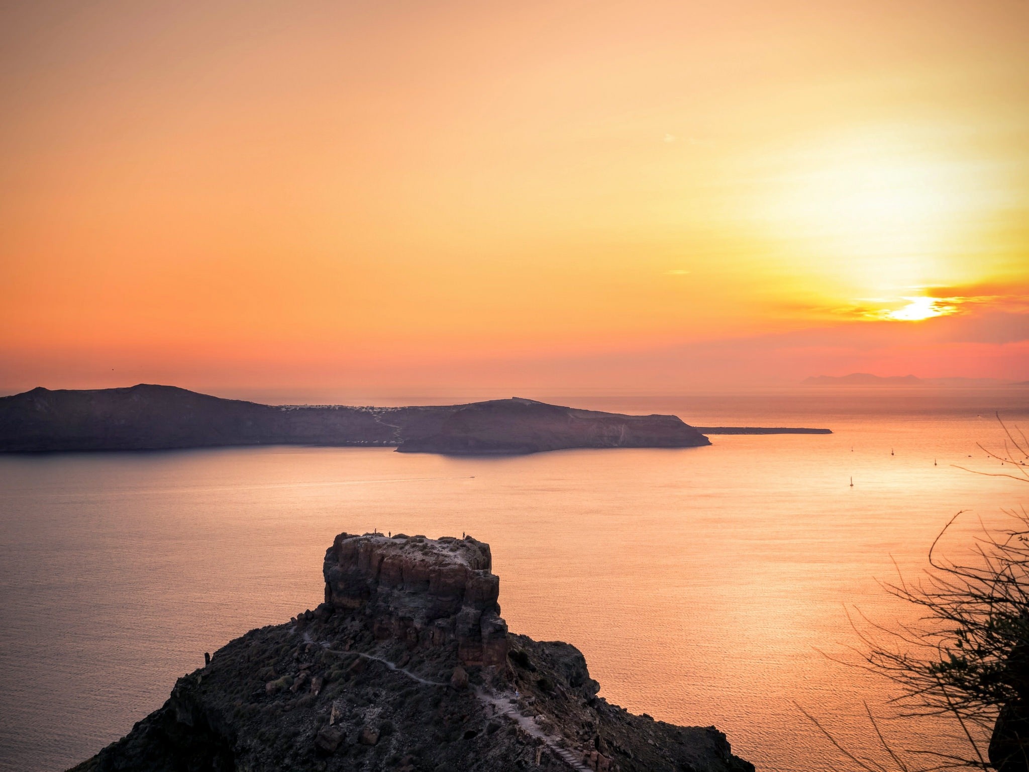 Sunset over the sea with islands and a rocky outcrop HD Wallpaper