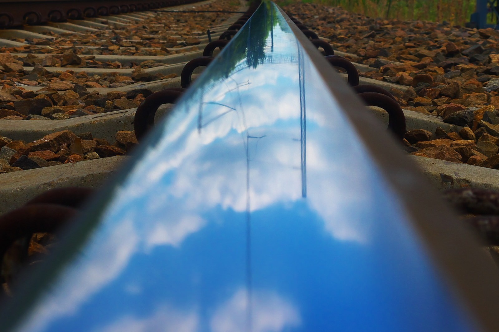 Reflection of clouds and sky on a train track HD Wallpaper