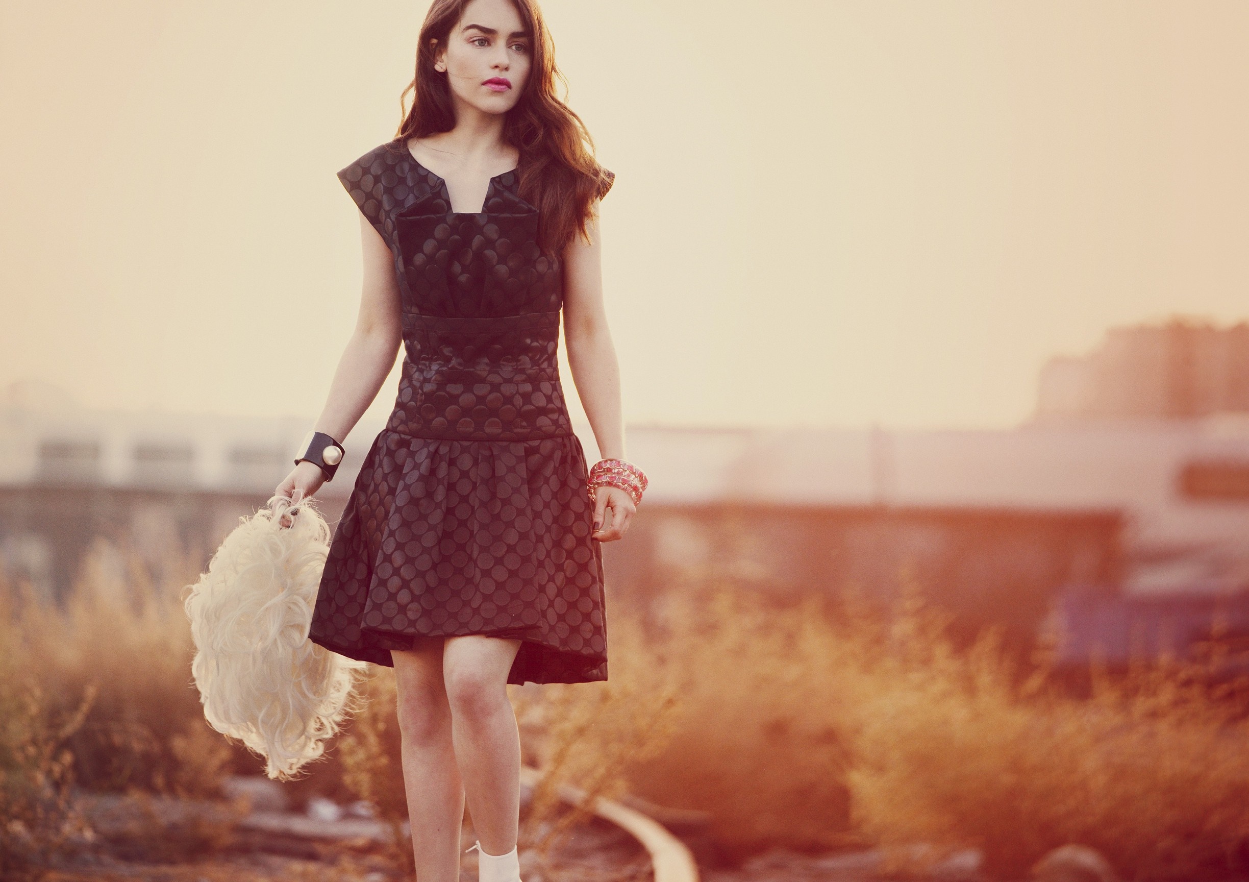 Emilia Clarke in a patterned dress holding a wig HD Wallpaper