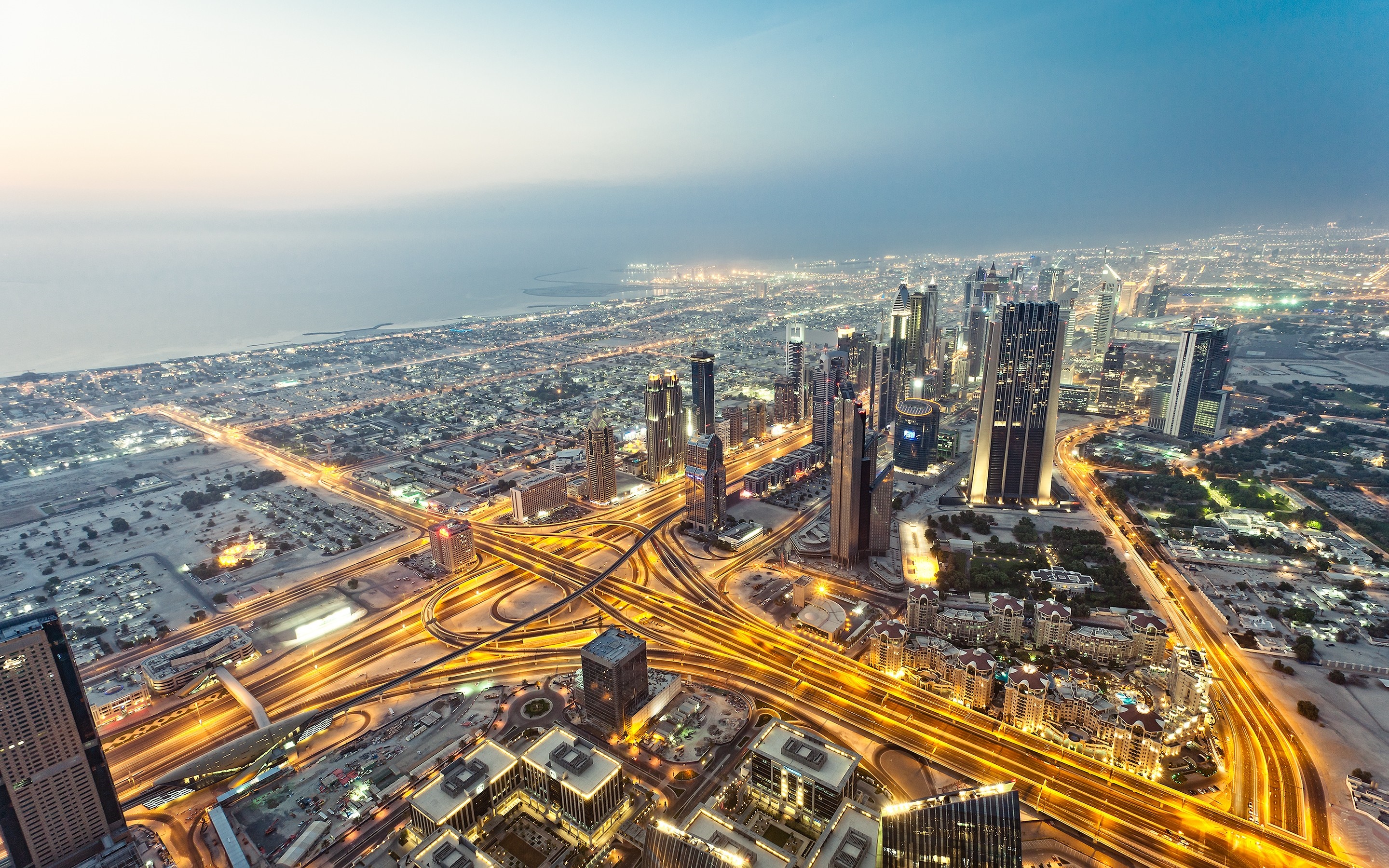 Dubai cityscape with illuminated highways at dusk HD Wallpaper