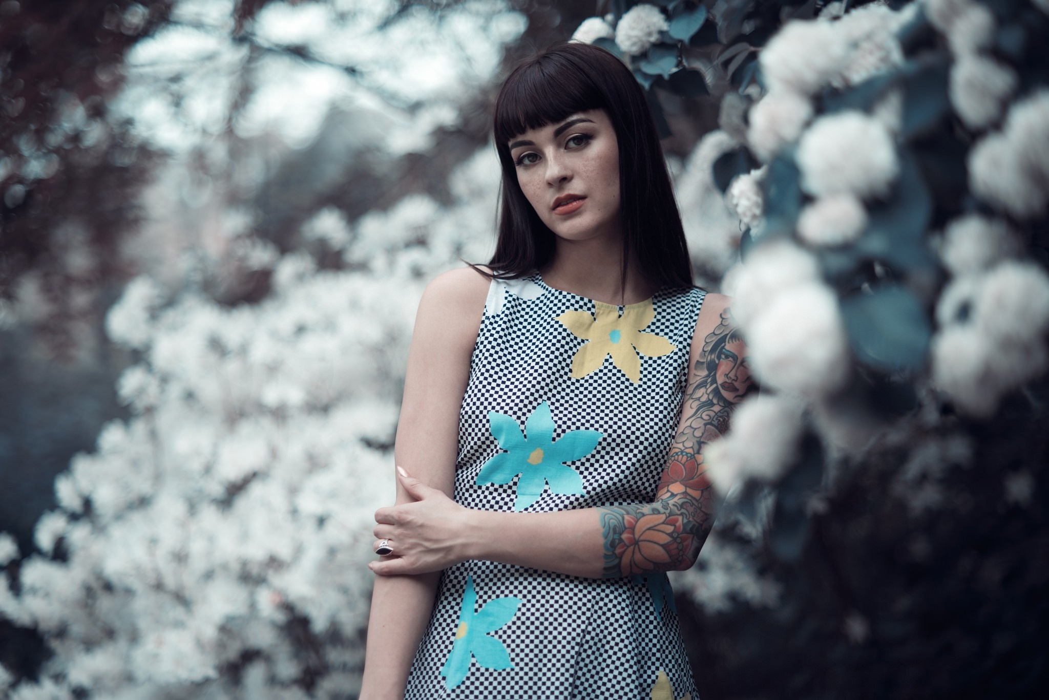 Woman with tattoos and floral dress in front of white flowers HD Wallpaper