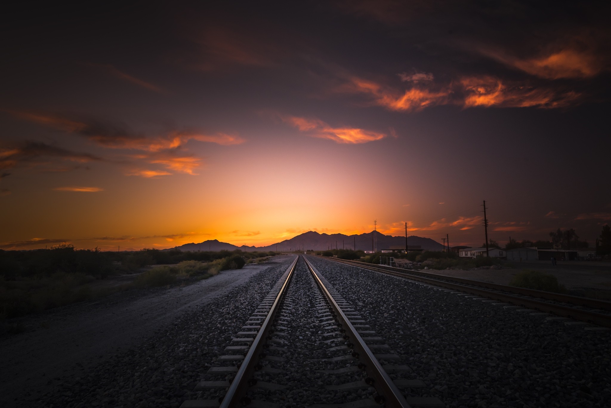Train tracks at sunset with mountains and clouds HD Wallpaper