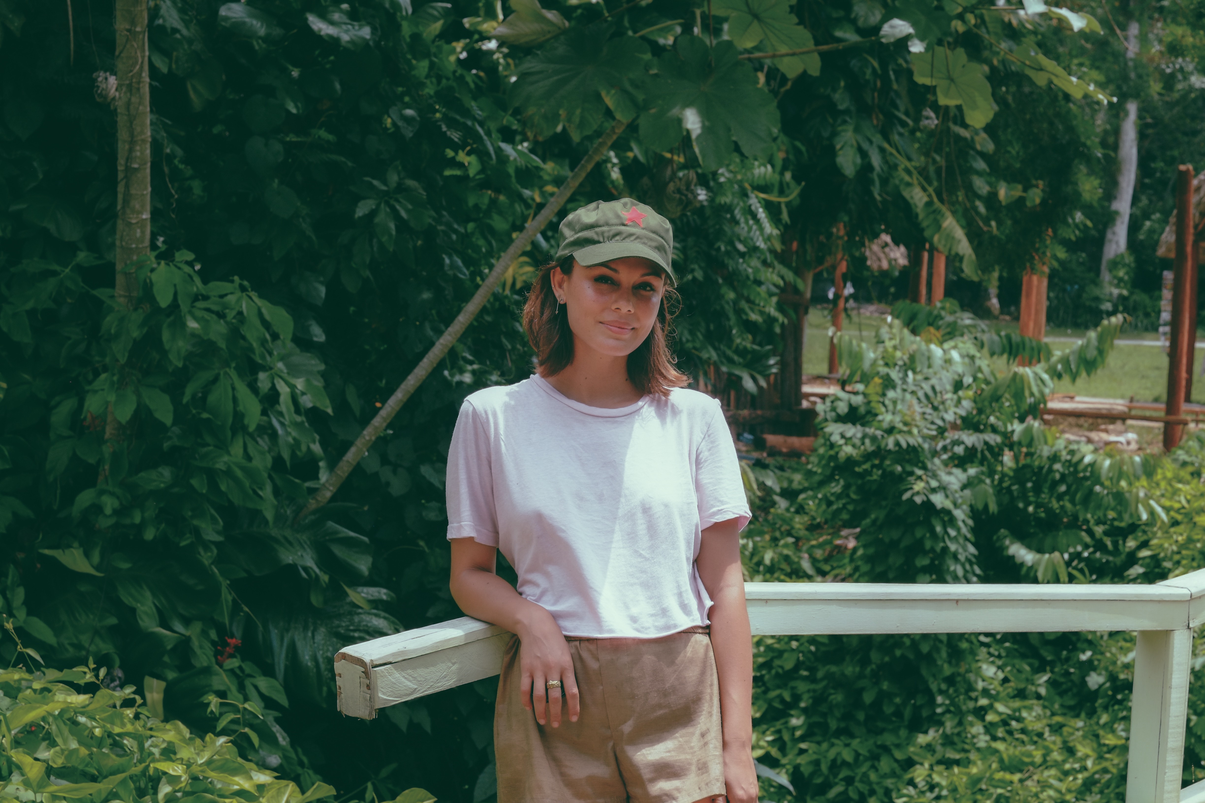 Nathalie Kelley in a garden wearing a cap and shorts HD Wallpaper