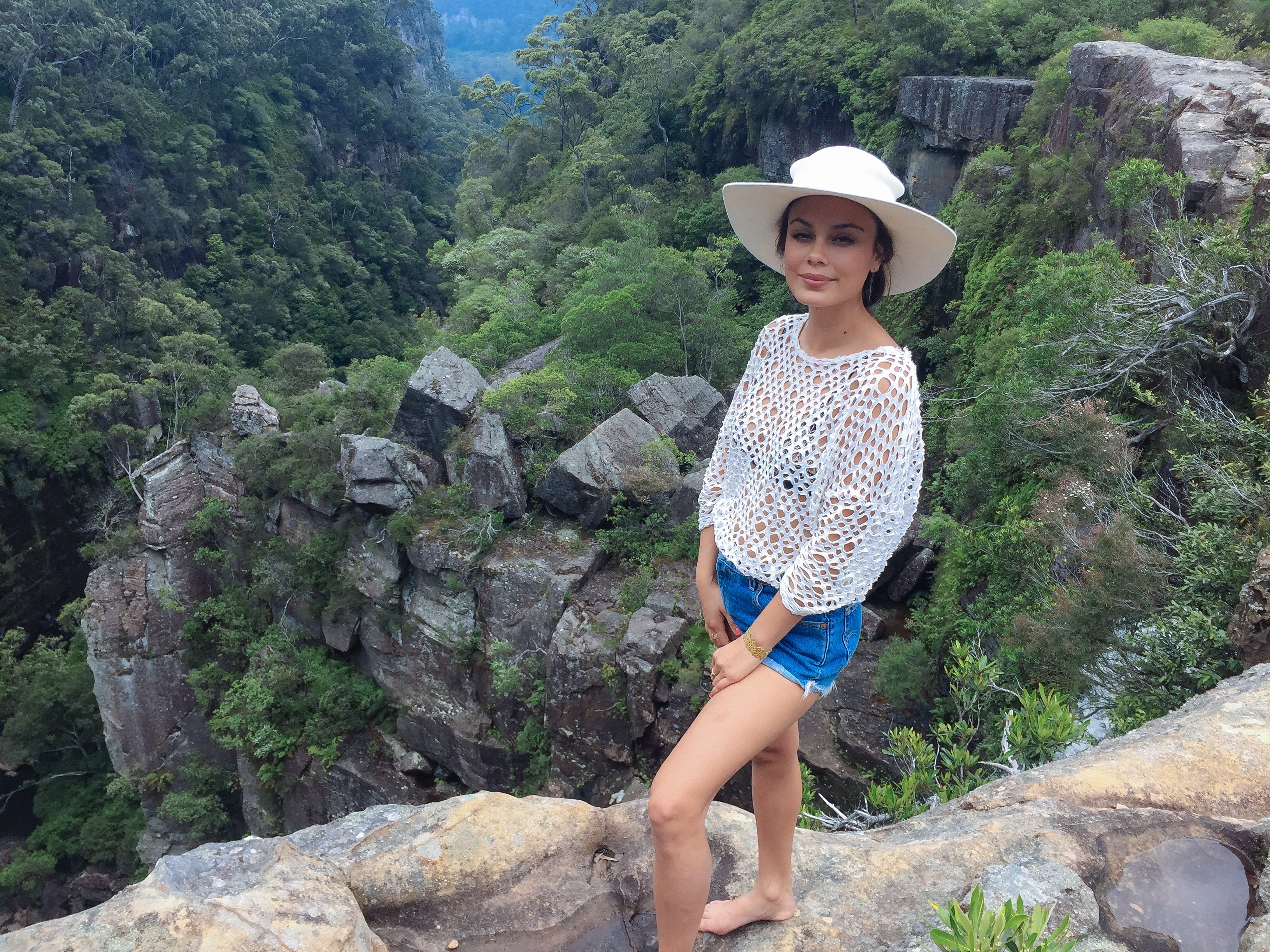 Nathalie Kelley on a cliff overlooking a forest HD Wallpaper