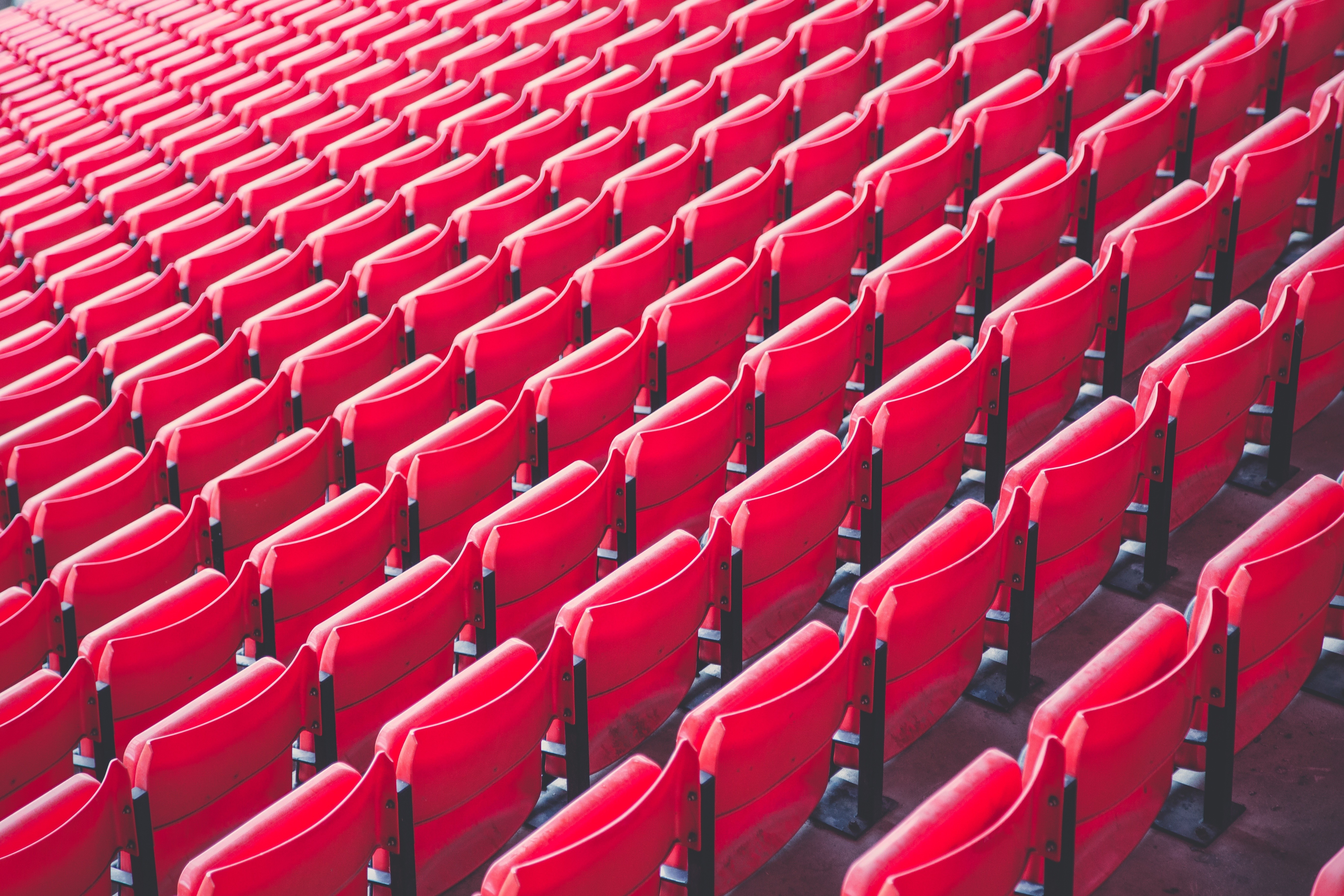 Rows of empty red stadium seats HD Wallpaper