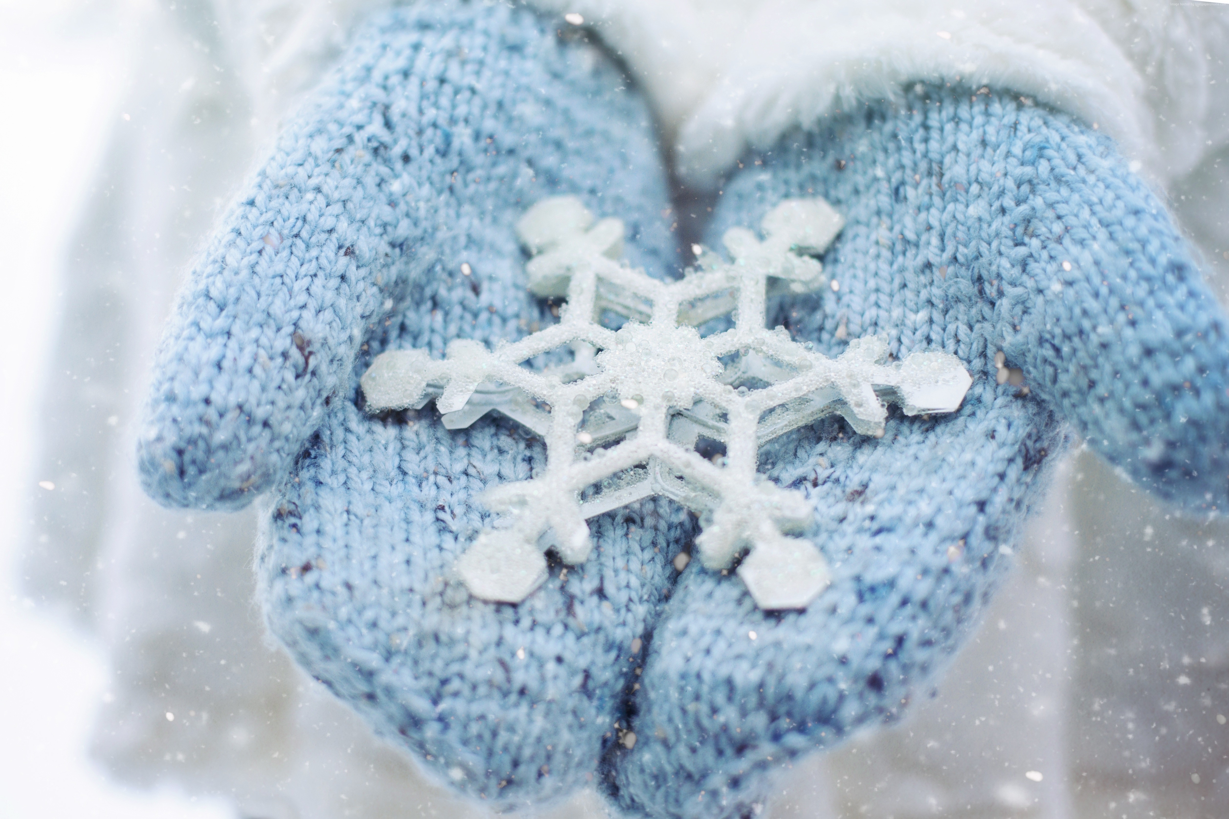 Hands holding a snowflake in winter HD Wallpaper