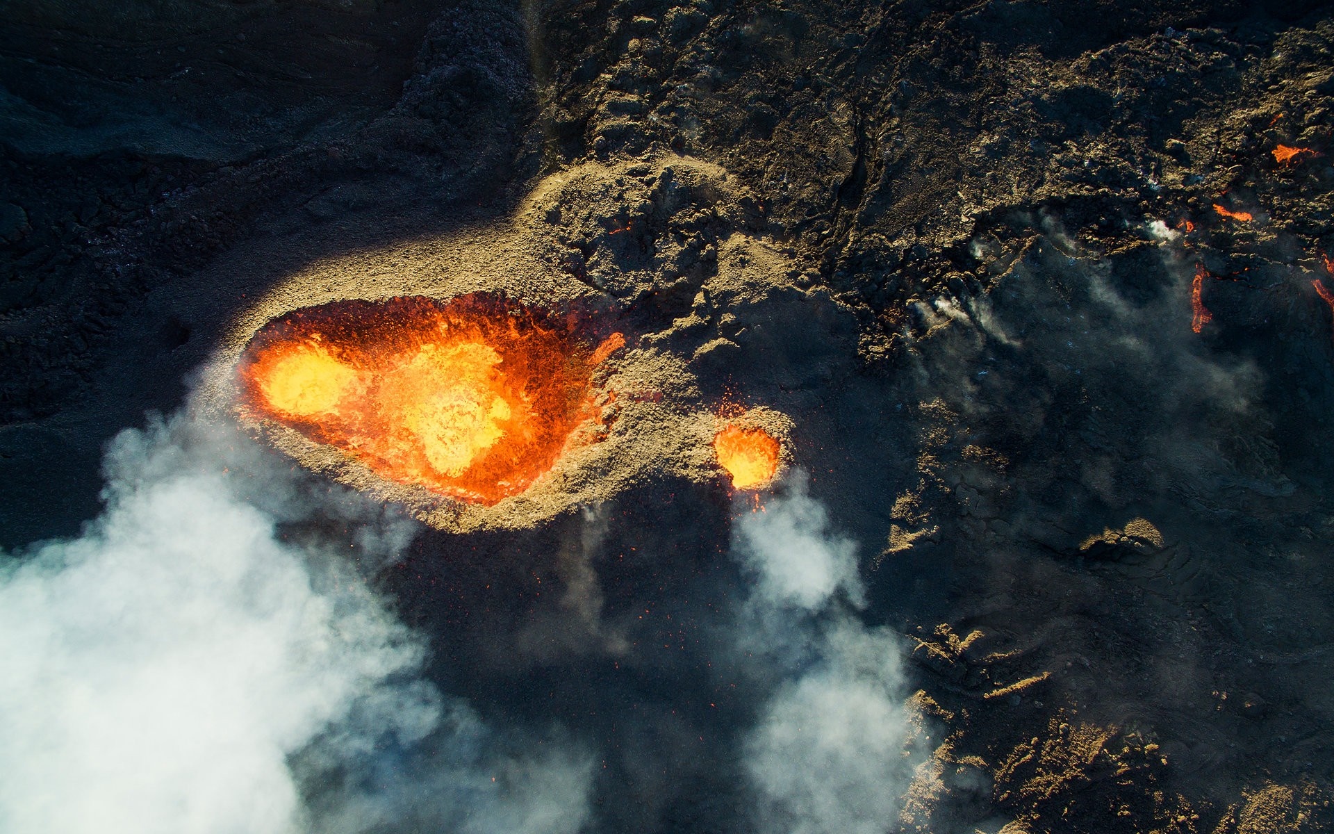 Aerial view of a volcanic eruption with lava and smoke HD Wallpaper