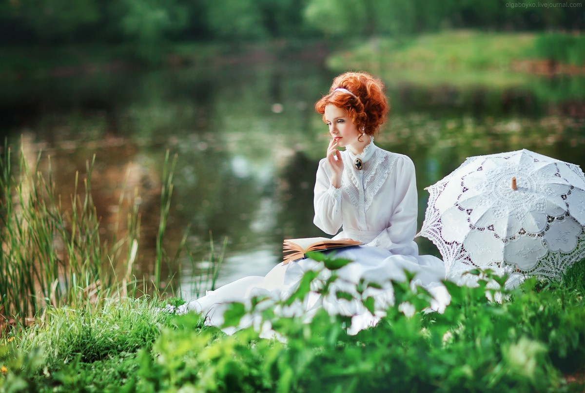 Redhead woman in white dress reading by a pond with umbrella HD Wallpaper