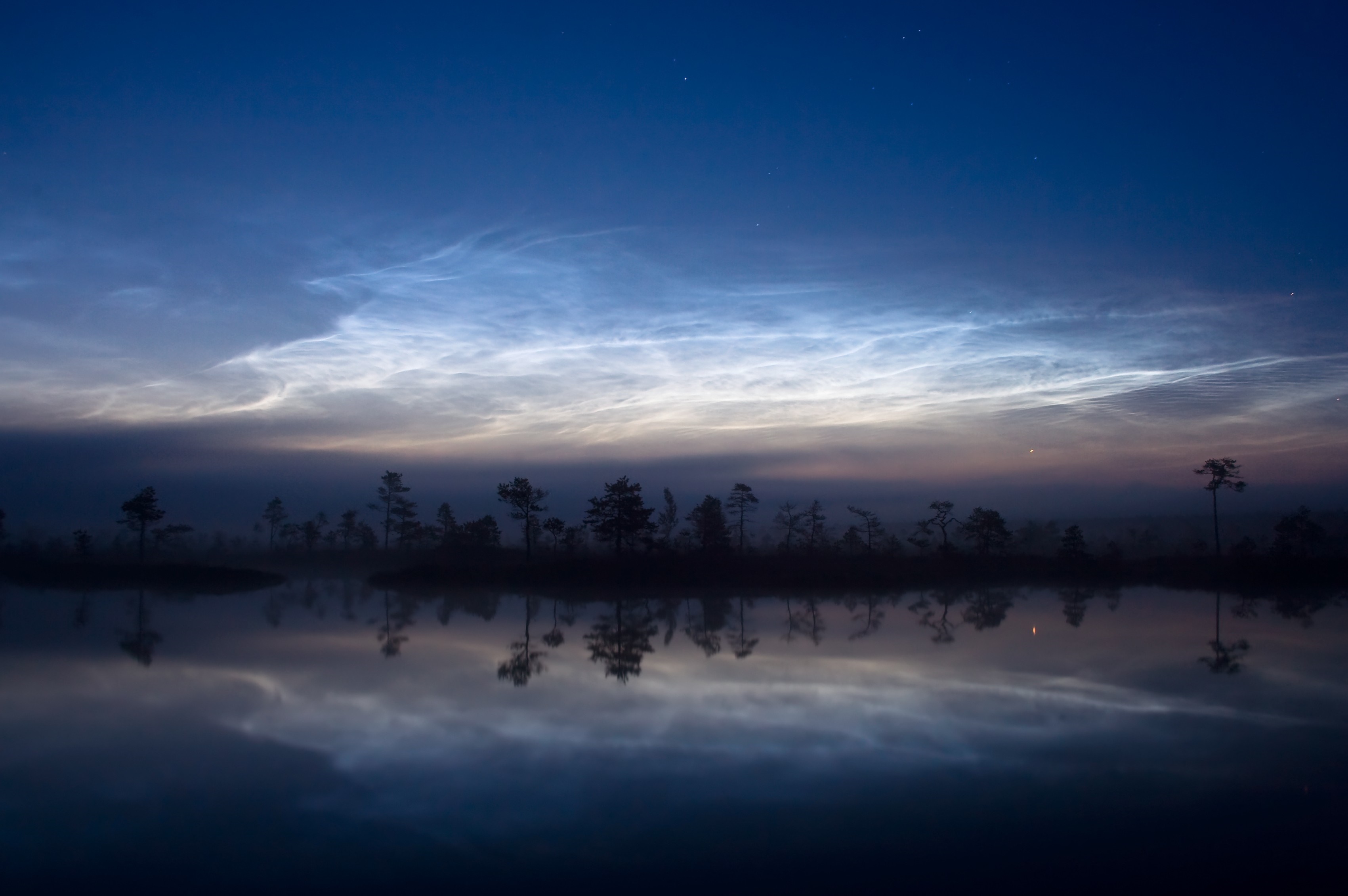 Noctilucent clouds over a misty wetland lake at dawn HD Wallpaper