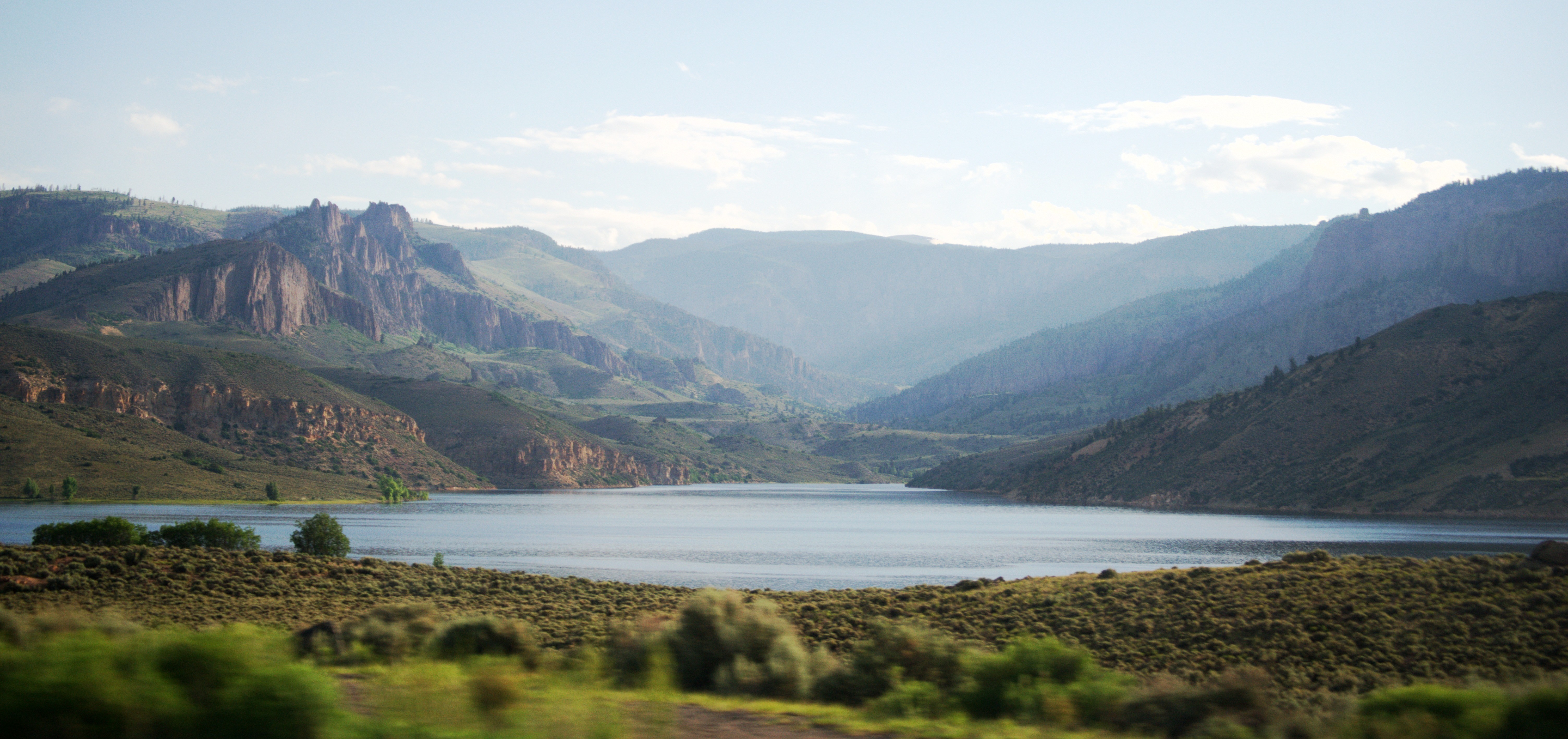 Mountain valley with a lake and rolling hills HD Wallpaper